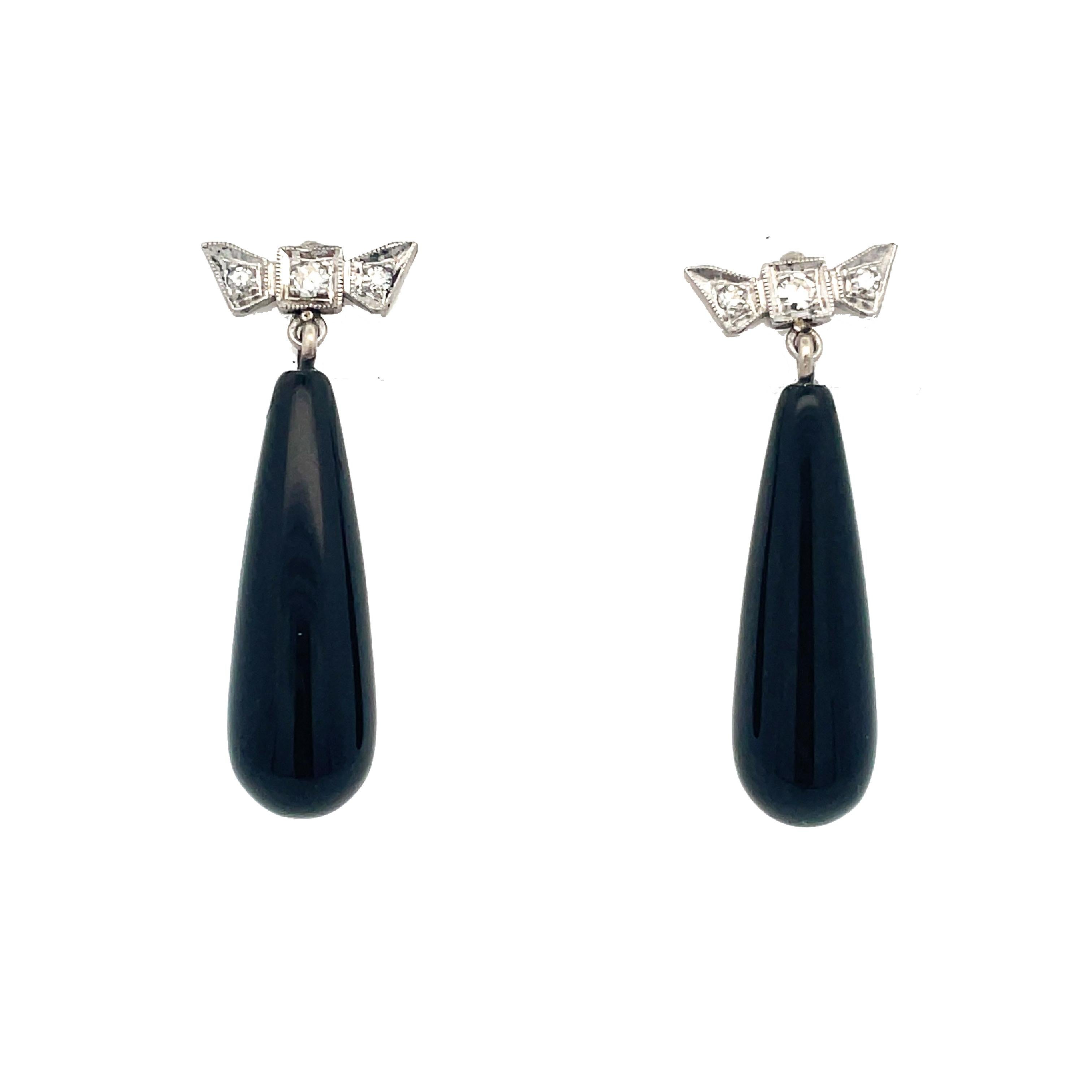 This is a stunning pair of Retro earrings crafted in 14K white gold that showcases beautiful black onyx dangles and sparkling single-cut diamonds! These earrings are elegant, sophisticated, and fully articulated! The earrings would look striking