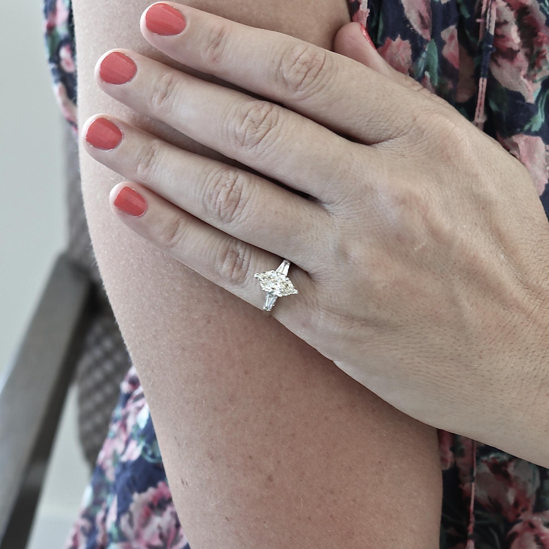 A well cut marquise diamond is a beauty to behold. Add to it the warmth of an O color, and VS1-2 clarity, and you can see why this ring is so charming. 
With tapered baguettes totaling approximately 0.40 carats, H-I color, VS clarity, the Retro