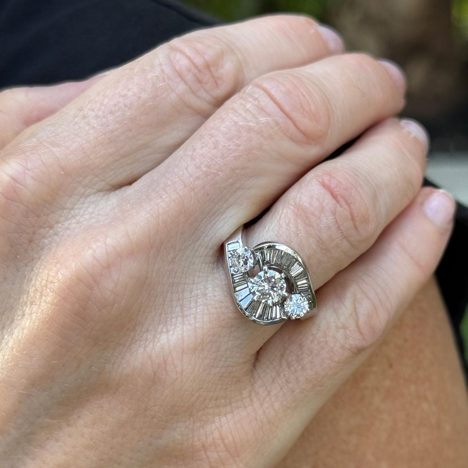 Dieser Diamantring aus 18 Karat Weißgold im Vintage-Stil ist ein atemberaubendes Beispiel für klassische Eleganz. In der Mitte sind drei runde Diamanten im Brillantschliff von Osten nach Westen gefasst, insgesamt etwa 1,00 Karat (Farbe H-I, Reinheit