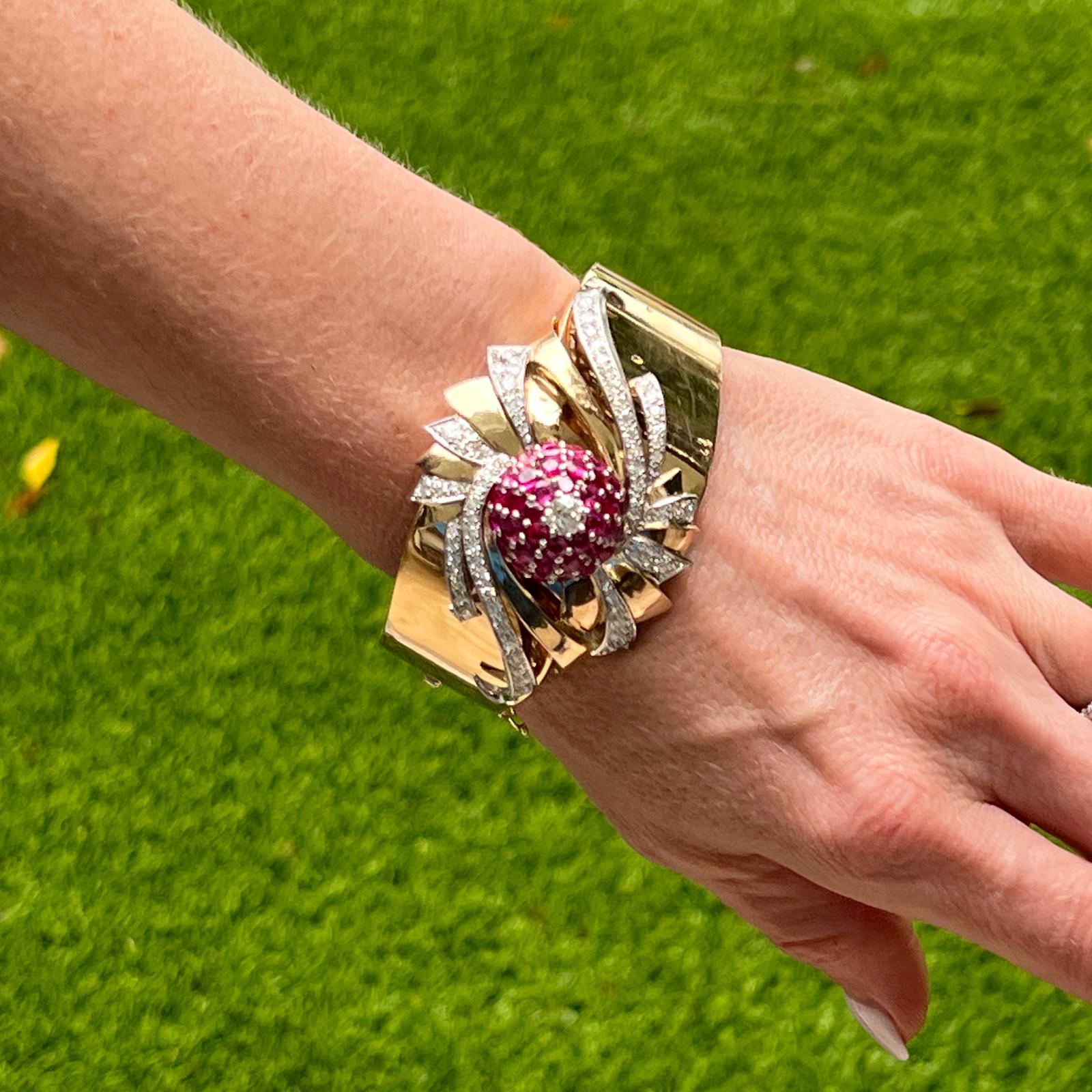 Fabulous Retro diamond and ruby bangle bracelet crafted in 14 karat rose gold. The bangle features 36 round rubies weighing approximately 9.00 CTW and 81 diamonds weighing approoximately 3.30 CTW. The diamonds are graded I-K color and SI clarity.