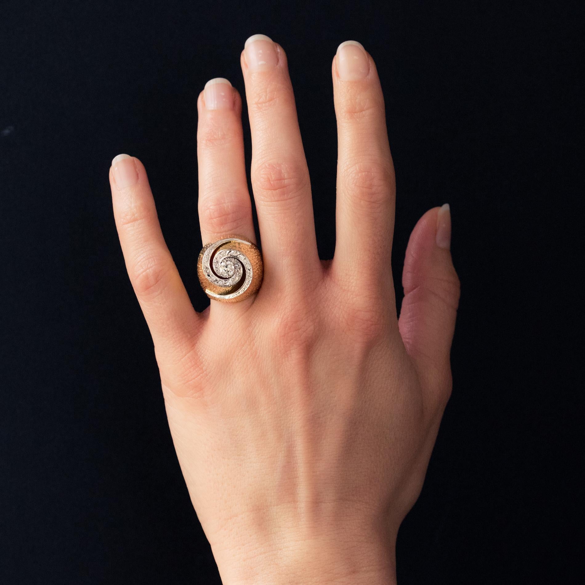 Ring in 18 karat yellow gold.
This superb retro ring forms a chiseled dome setting, the top of which has a modern brilliant-cut diamond, set in the center of an openwork swirl, itself set with diamonds.
Weight of the central diamond : approximately