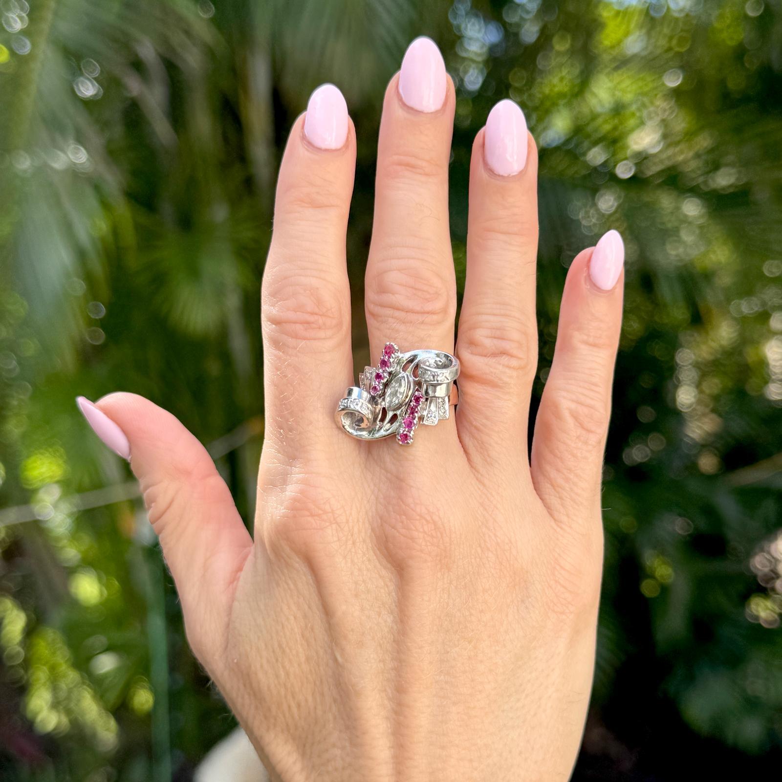 18 karat two-tone (white and rose gold) Retro swirl ring, artfully designed with a captivating center marquise diamond of approximately 0.30 carats at its center. The graceful curves and swirls are accented with 12 sparkling single-cut diamonds