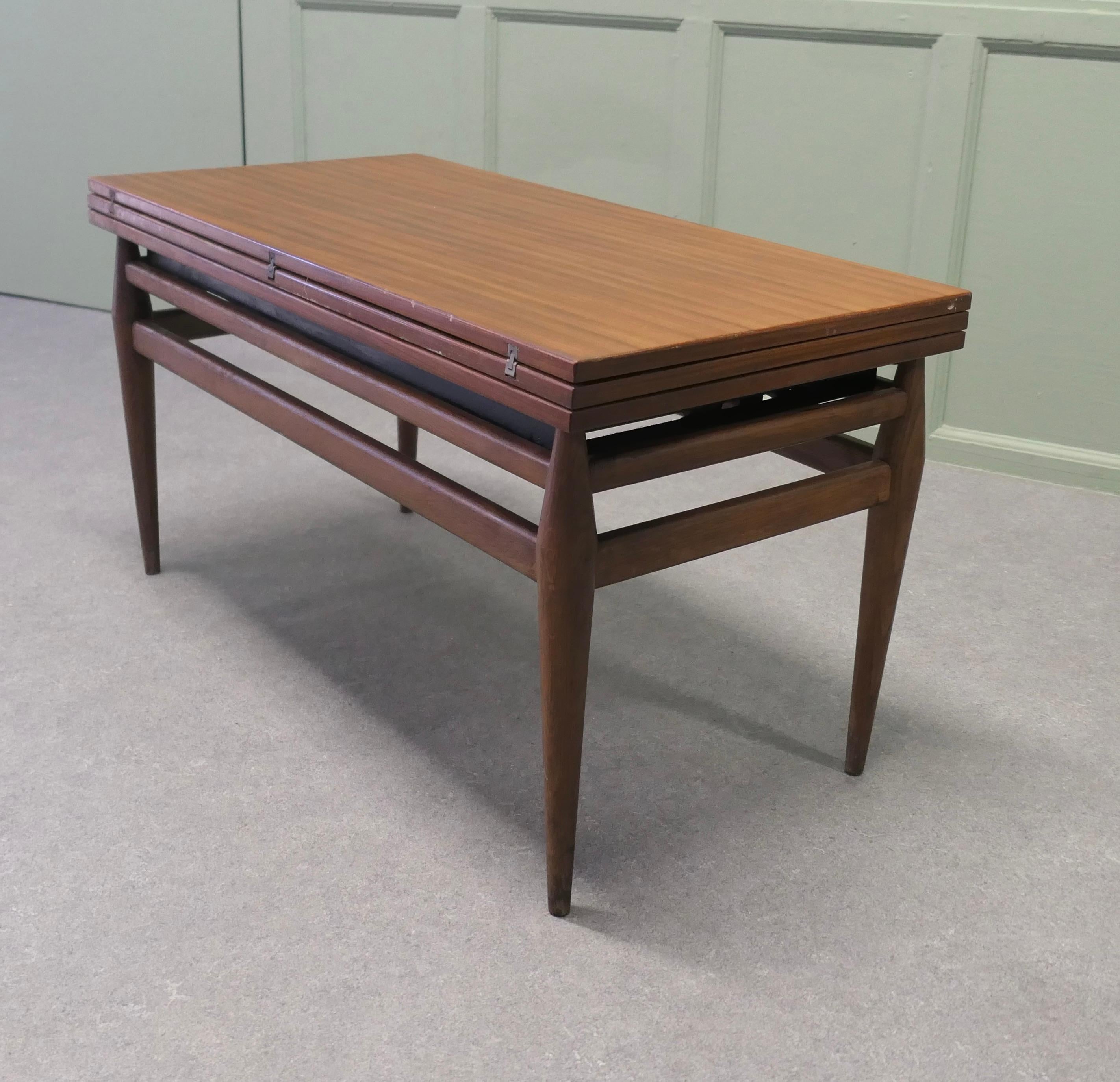 1950s Retro Metamorphic Coffee/Dining Table

A truly ingenious table first as a rectangular coffee table, adjust upwardly and by unfolding the leaves it becomes a dining table, along the way you may just want a Large Coffee table
The table mechanism