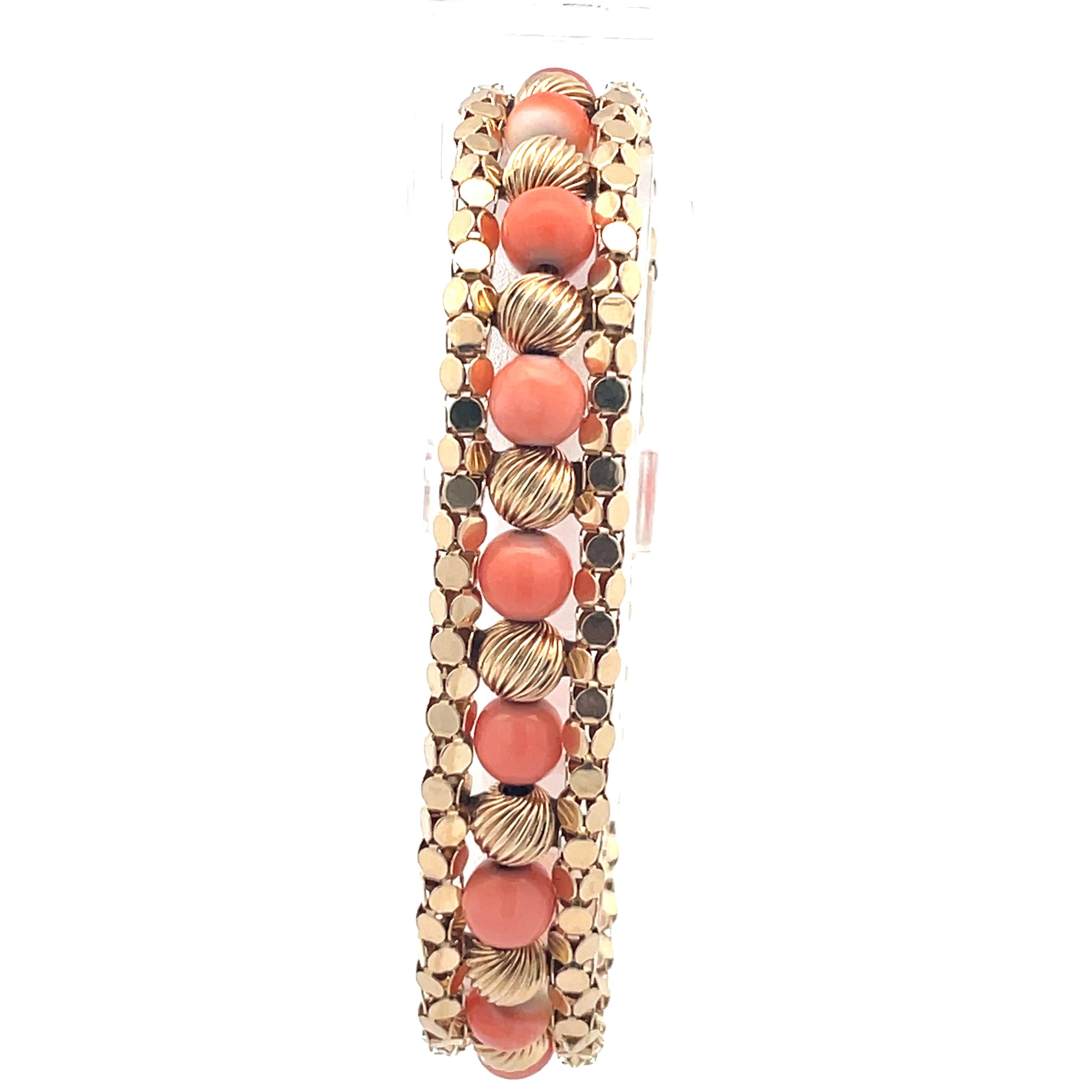 This 7.5” natural coral and 14k yellow gold bracelet is a truly stunning wearable piece of art. The vibrant colors of the coral contrast beautifully with the round fluted gold beads stacked between them to create an elegant bracelet with a