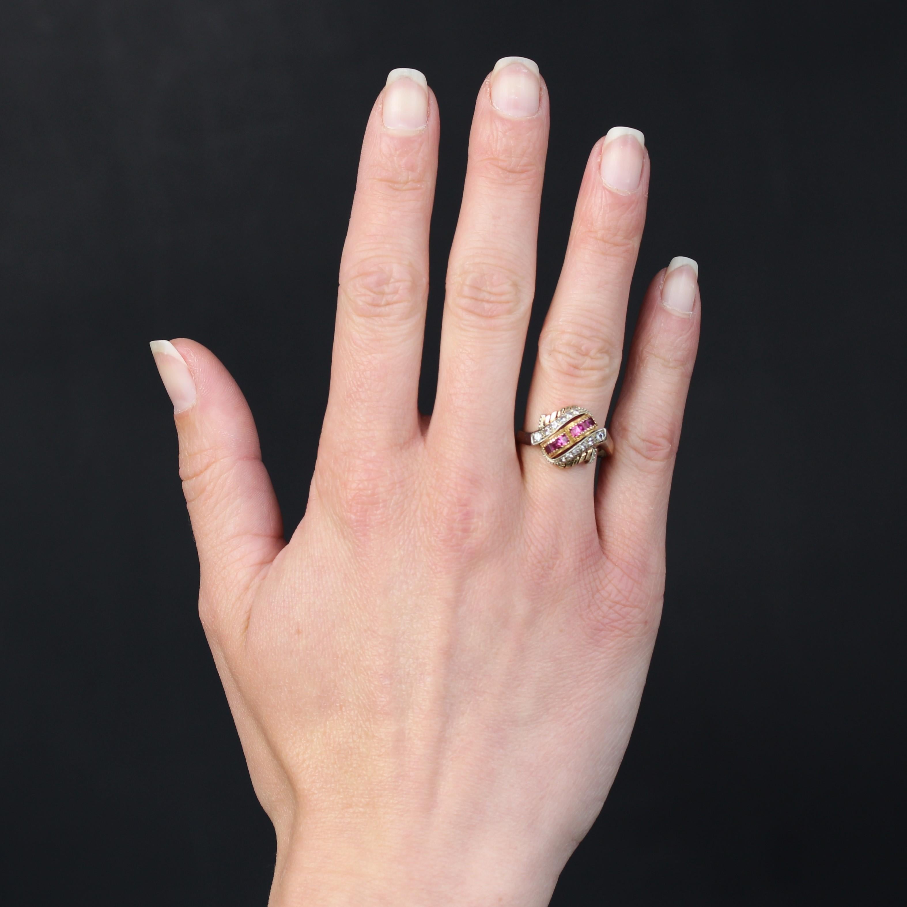 Ring in 18 karat rose and white gold.
An original retro domed ring, it forms 2 polylobed rose gold settings on top, each set with 3 calibrated red gems. On either side, a line of 6 falling white stones set in white gold and bordered by a millegrain