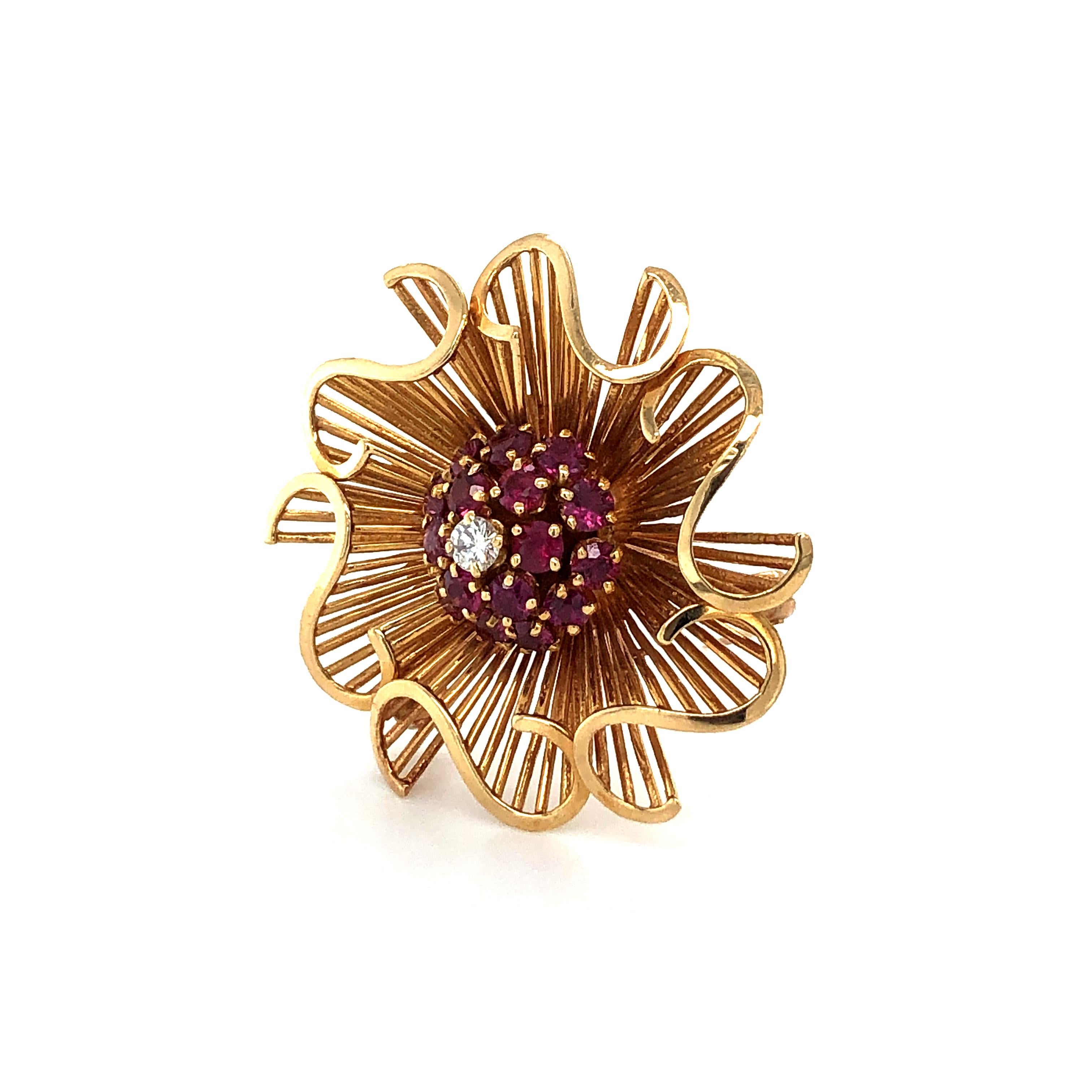 This fabulous 1950s Retro brooch in 14K rose gold is designed as rays arranged in waves surrounding a gemset center. The bombé shaped center of attraction is pavé set with 17 round cut rubies encircling a brilliant-cut diamond.

A very classy look