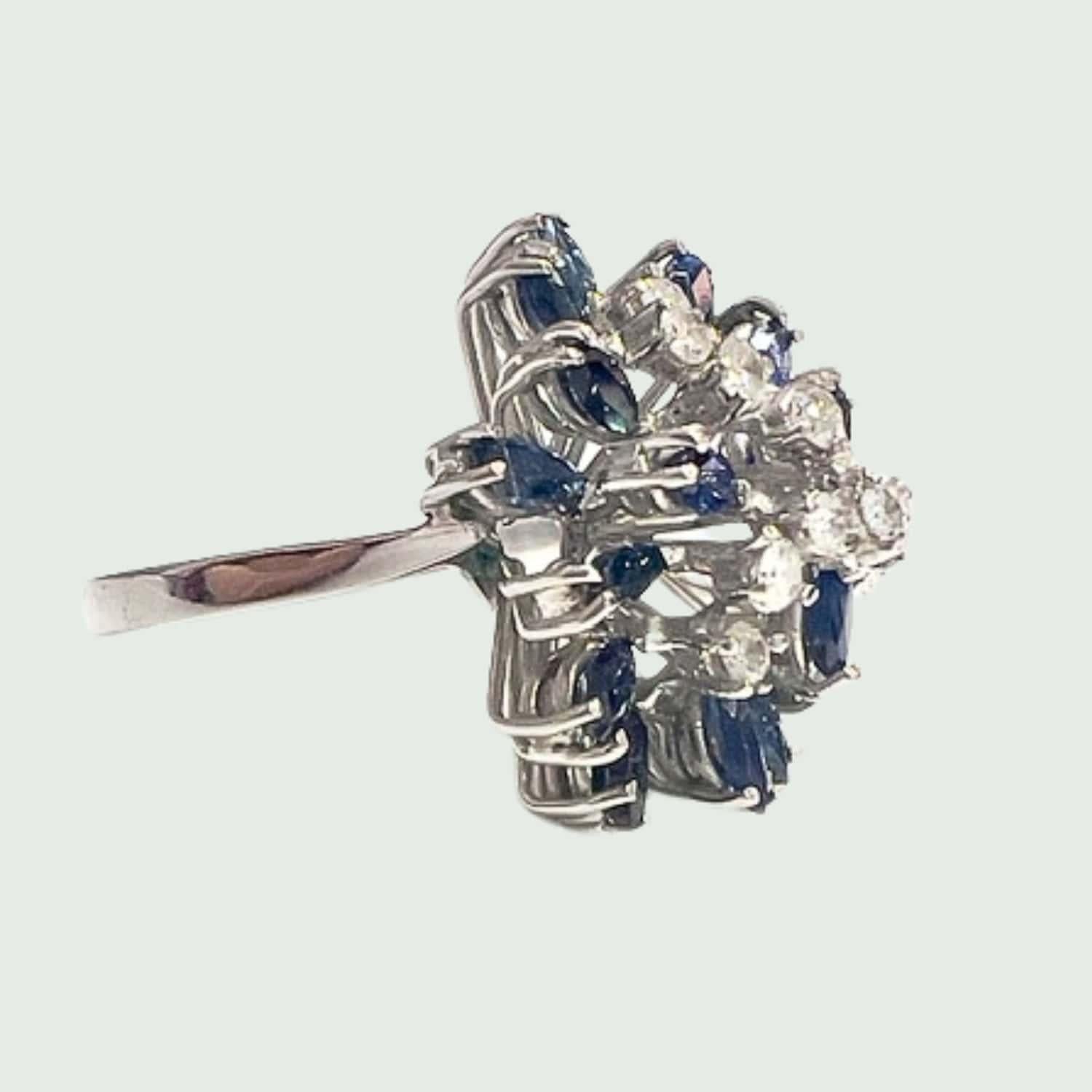 Step back in time to the glamorous 1950s with this stunning retro ring crafted from 18k white gold, adorned with brilliant-cut diamonds and navette-cut sapphires. This ring exudes vintage charm and sophistication, making it a standout piece in any