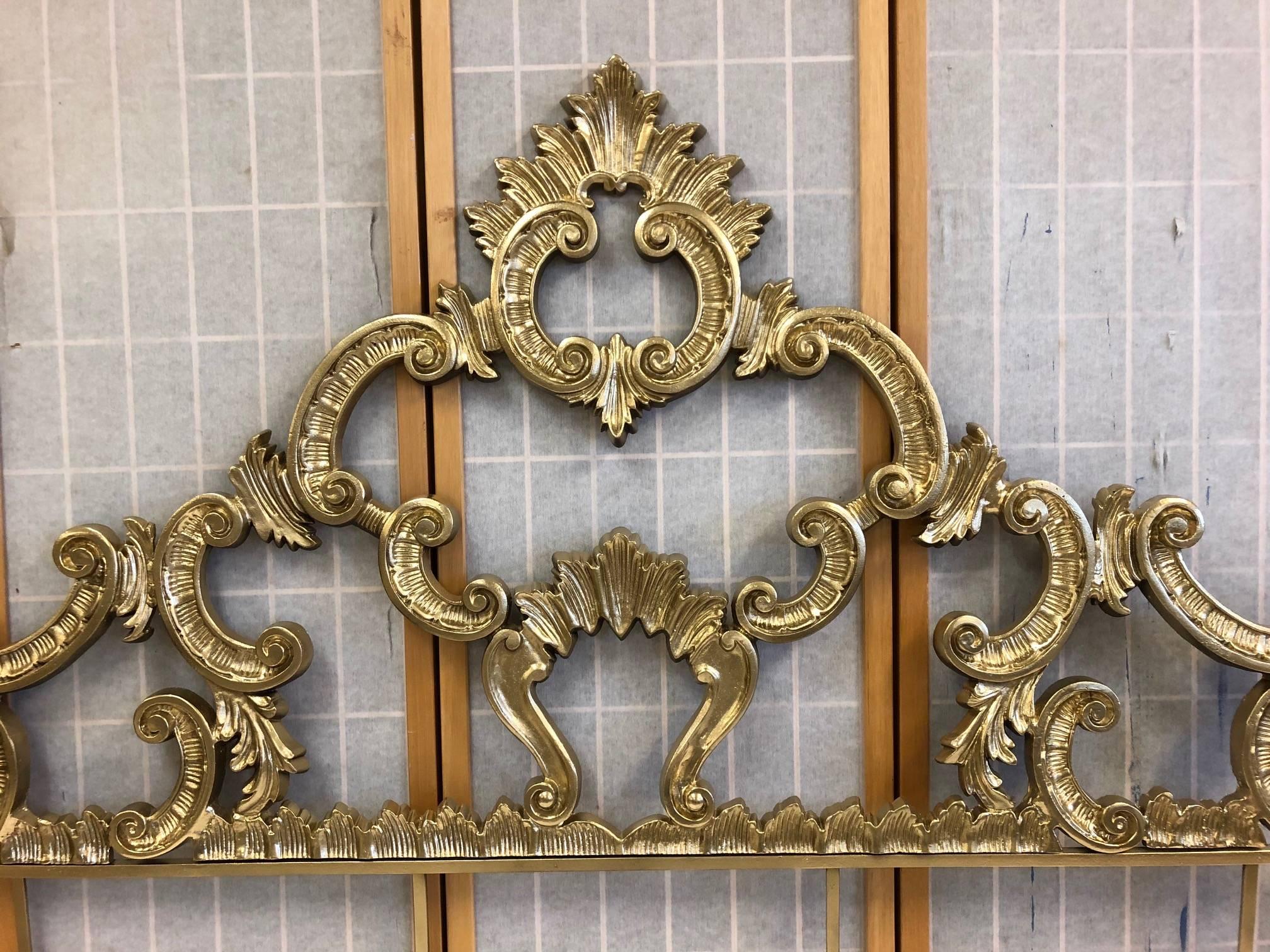 1950s Rococo style headboard that is gold painted metal finish. Has a wonderful decorative pattern. Overall measures: 55 H x 60 W. From hole to hole the width is approximate 58 W.