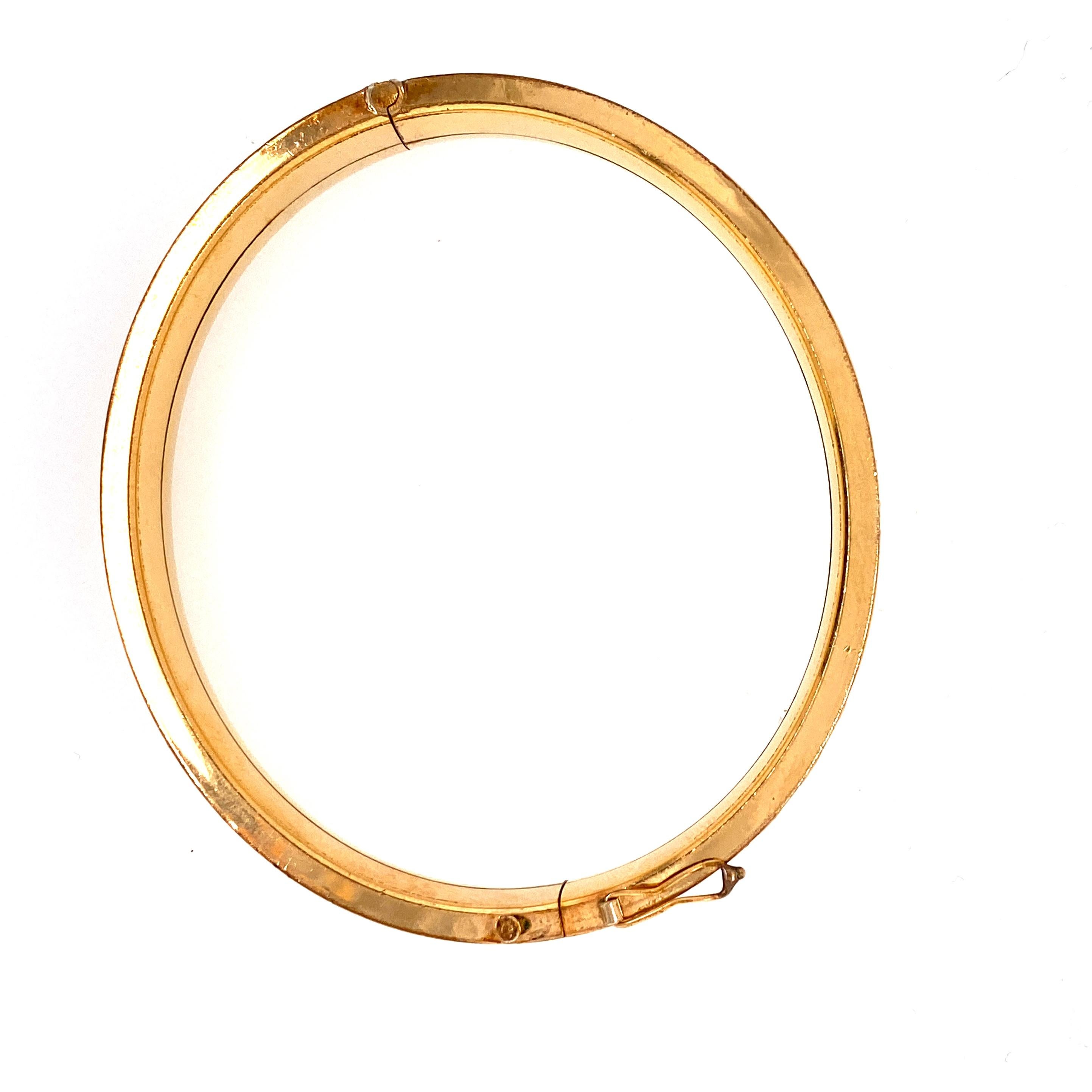 One 14 Karat rolled gold plated (stamped 14KRGP GERMANY) engraved hollow bangle bracelet measuring 10mm wide, with hinge hidden clasp with figure eight safety.  Circa 1950s.  