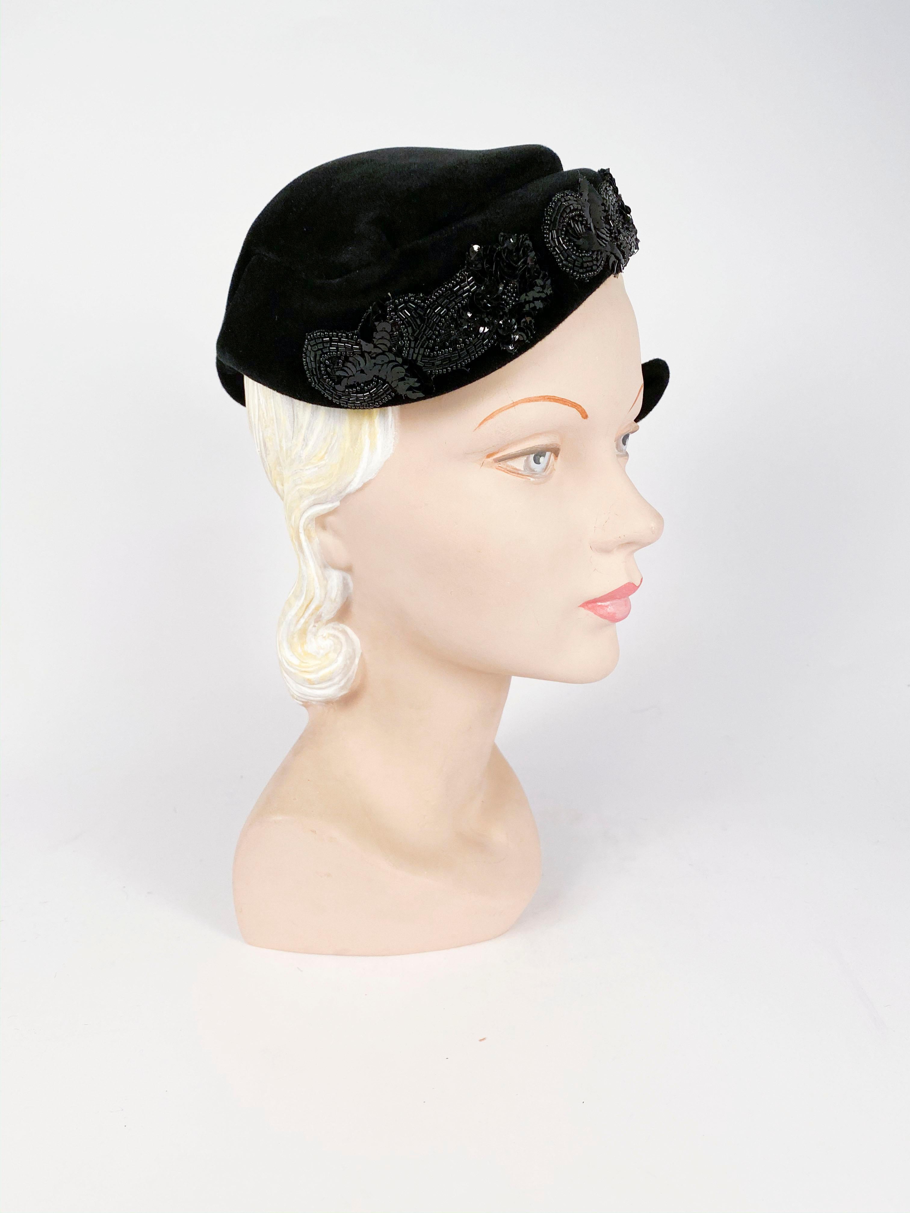 1950s Roos Bros. Black Velvet Hat featuring a black beaded and sequin appliqué to accentuate this hat's asymetrical shape. The body of the hat was made in France and it has an interior comb to reenforce this hat to the head.  