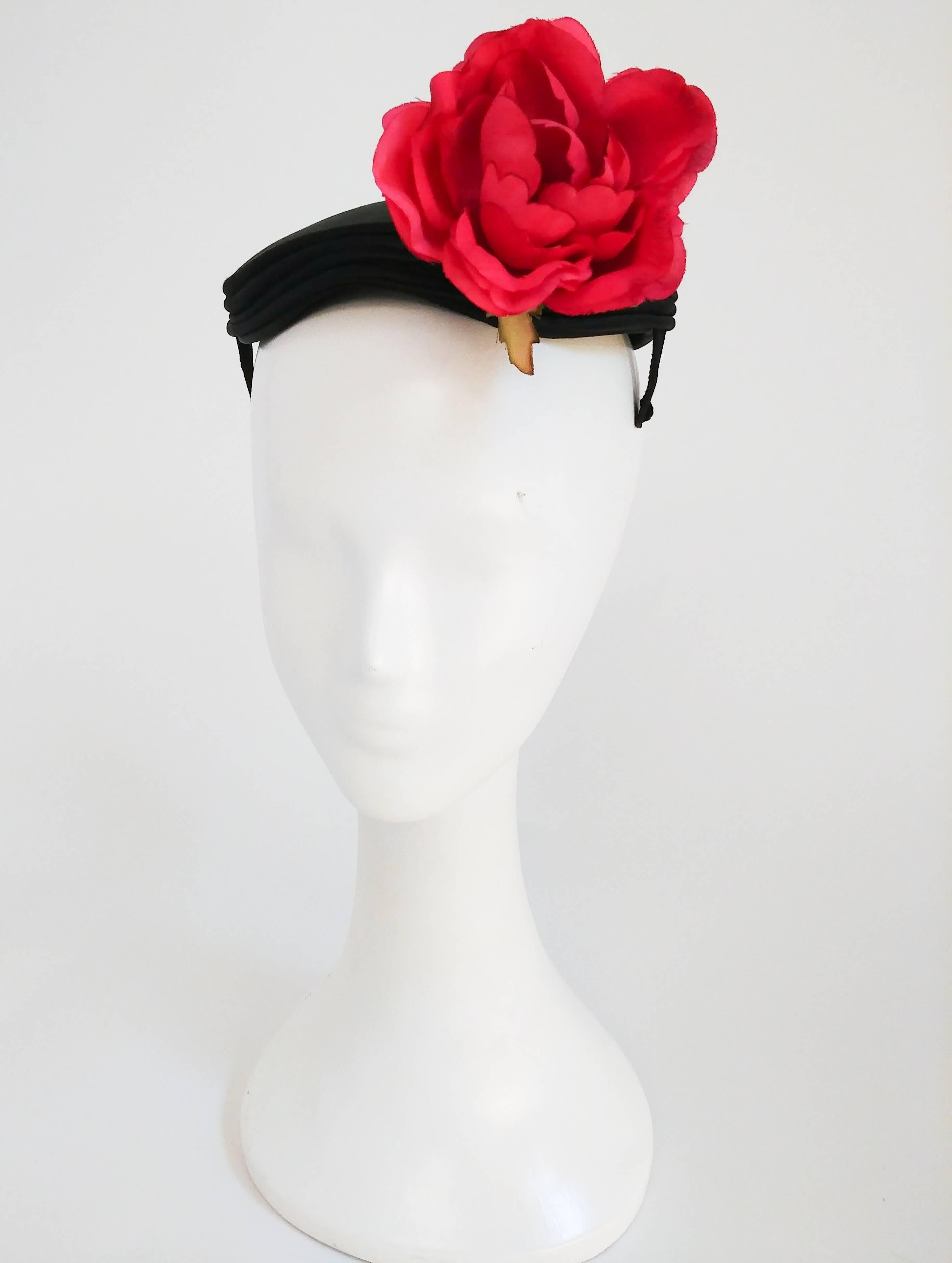 Chapeau à ornementation de roses des années 1950. Chapeau en satin avec une seule grande rose et un passepoil décoratif en satin. 