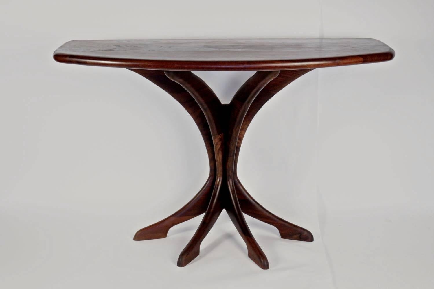 1950s rosewood console Osvaldo Borsani. 

Composed of a large semi-circular arched top in solid rosewood resting on four curved solid rosewood legs distributed in the form of a fan meeting on the lower part and forming a pretty base formed by the 4