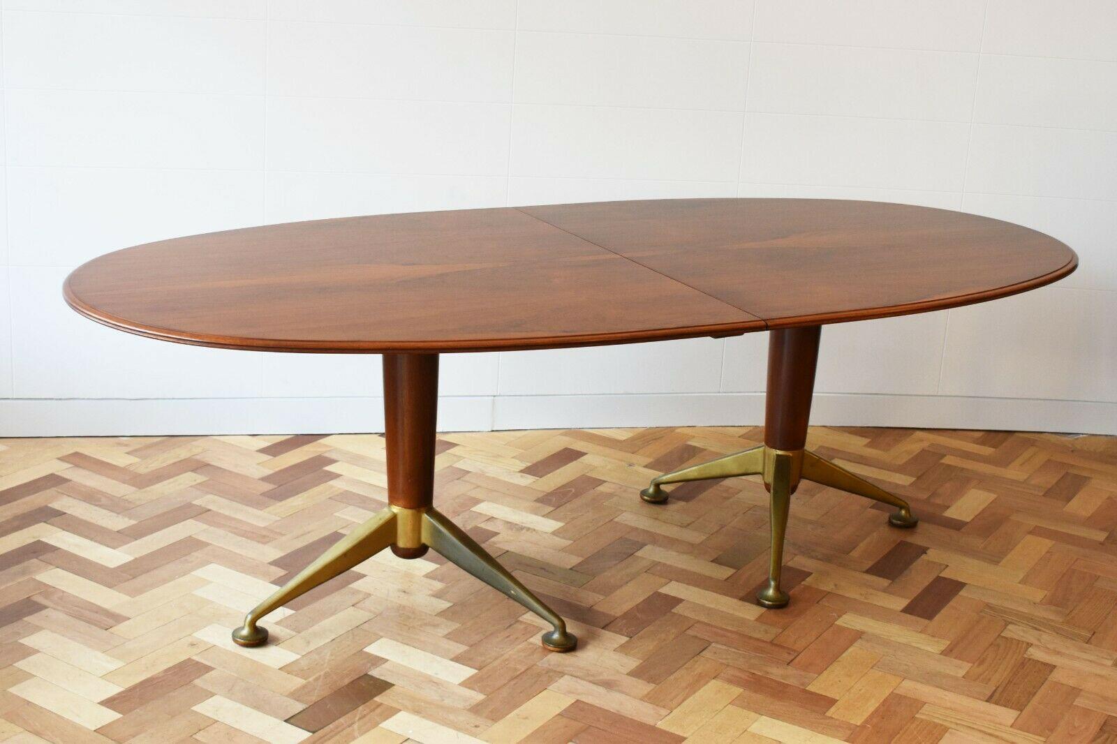 1950's Rosewood dining table with brass feet by British designer Andrew J Milne for Heals London. 

This oval rosewood dining table boats a twin pedestal base along with unique and striking brass splayed feet.

Originally, this table would have