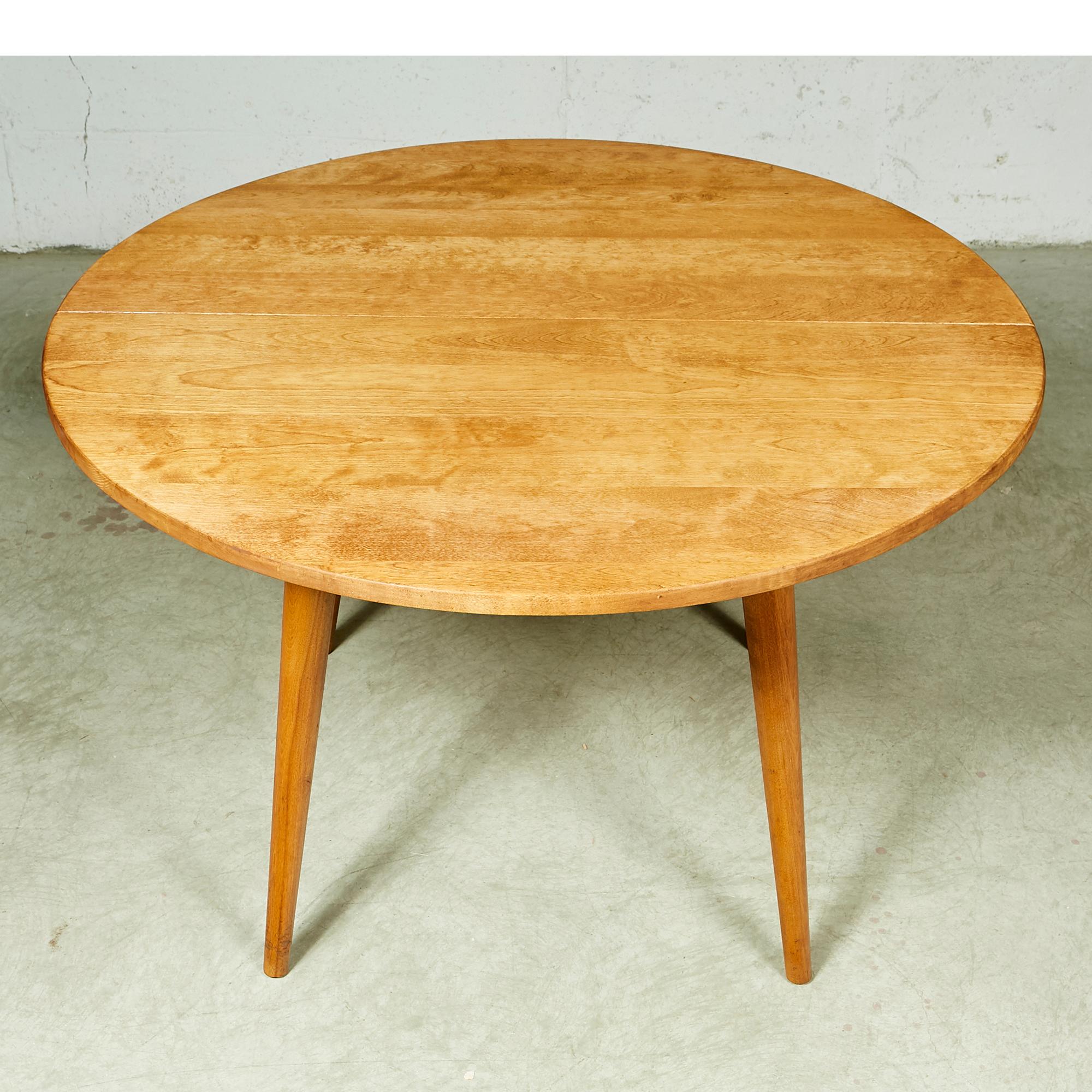 Vintage round maple wood dining table in newly refinished condition with round legs. No maker's mark.
