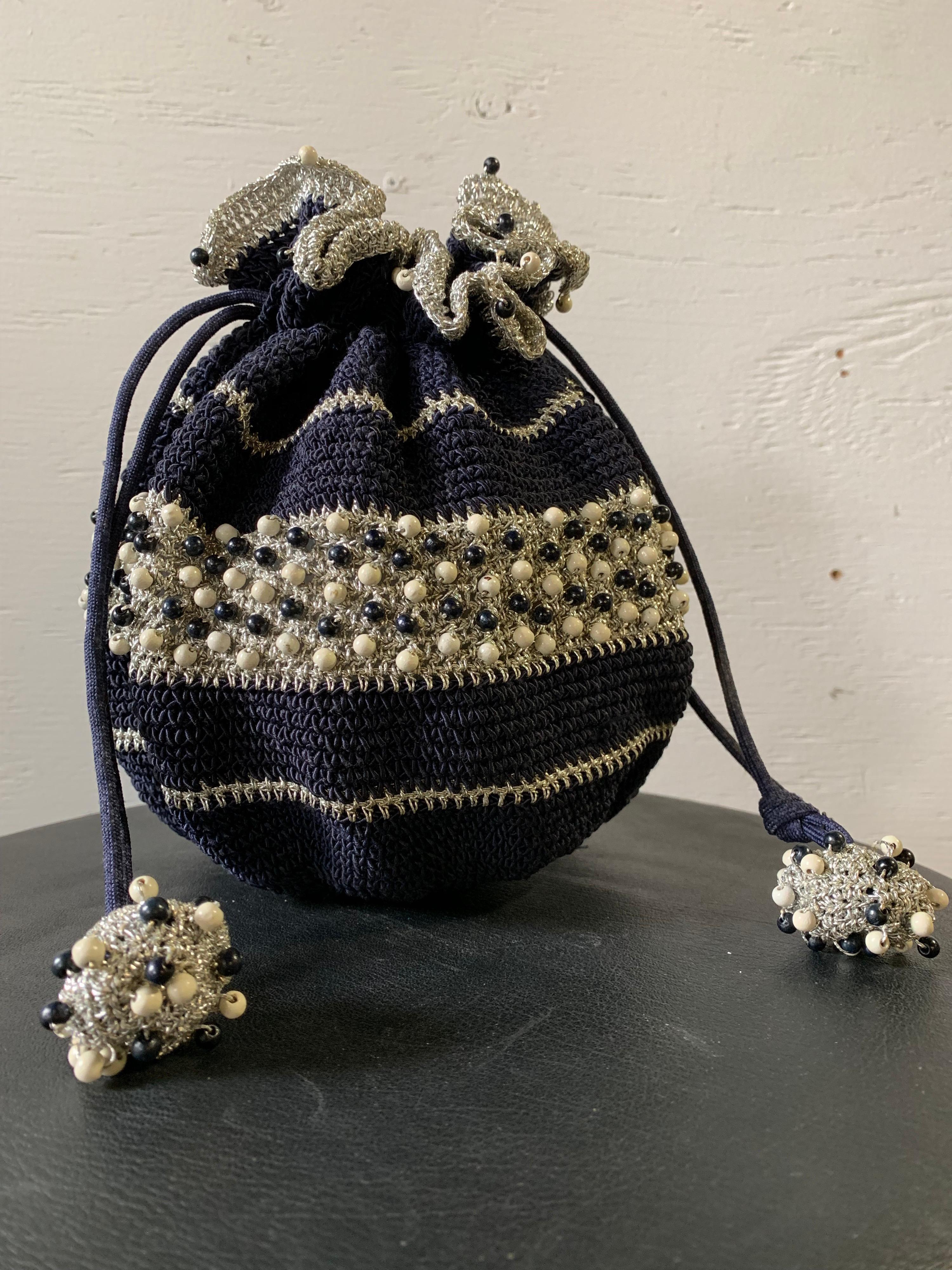 sac à main d'été à cordon en crochet des années 1950, de couleur marine et argentée, avec perles en bois. Fond en résine et boutons en forme de boule aux extrémités du cordon.