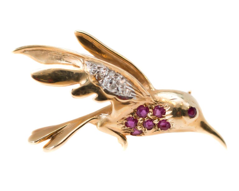 1950s Retro Ruby and Diamond Flying Bird Pin - 14 Karat Yellow Gold, Rubies, Diamonds

Features:
7 Natural Round Rubies
6 Round Brilliant Diamonds
Pinkish Red Rubies
14 karat Yellow Gold
Details include Feather textured Wings and Tail, Curved