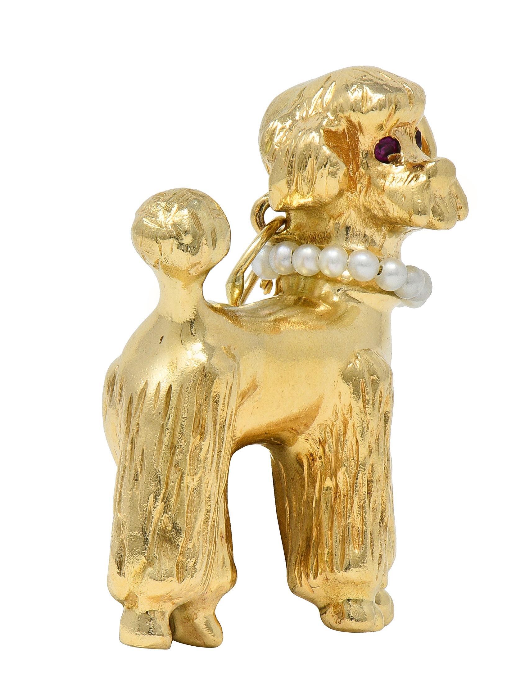 Conçu comme un chien caniche dimensionnel en or jaune avec une fourrure texturée.
Accentué par des rubis ronds de 1,5 mm de diamètre sertis comme des yeux.
Transparent de couleur rouge rosé moyen
Portant un collier de perles de rocaille
Couleur du