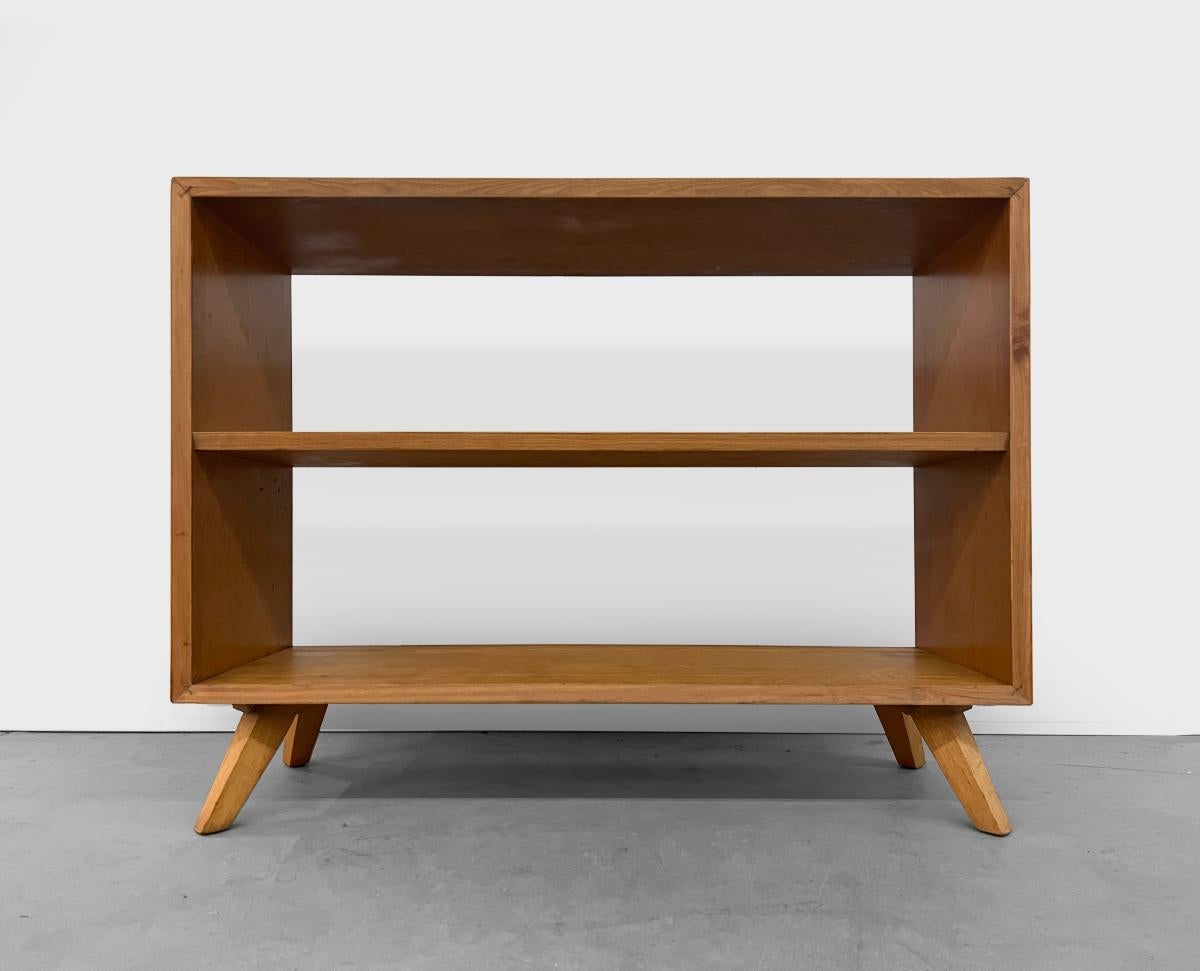This 1950's bookshelf is from the Ruspan Originals line by Russell Spanner. This line featured a clean, simple and boxy look with splayed out legs creating a futuristic look at the time which are evident in this bookshelf. In very good vintage