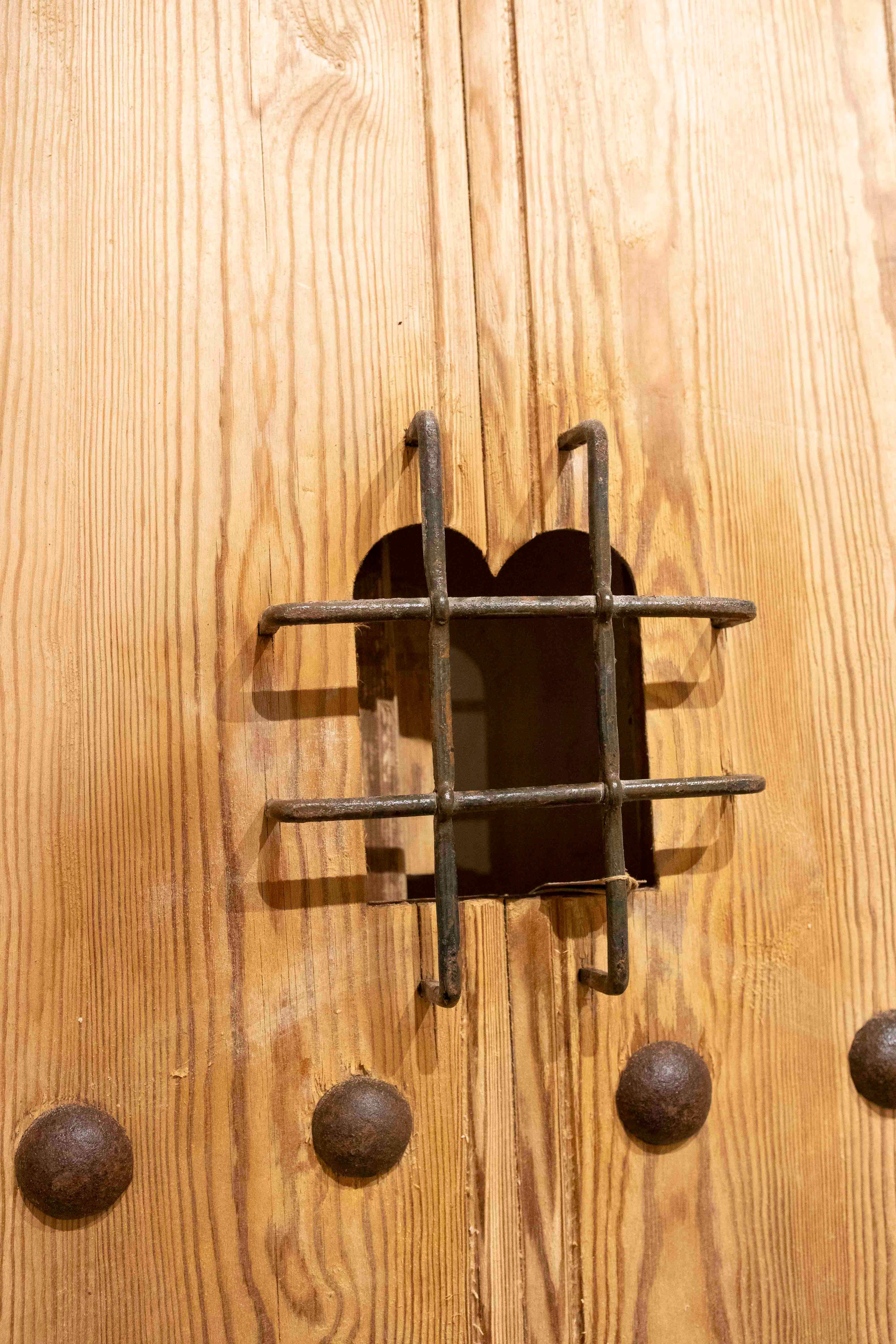 Puerta rústica española de madera de los años 50 con clavos forjados y reja central de hierro en venta 6
