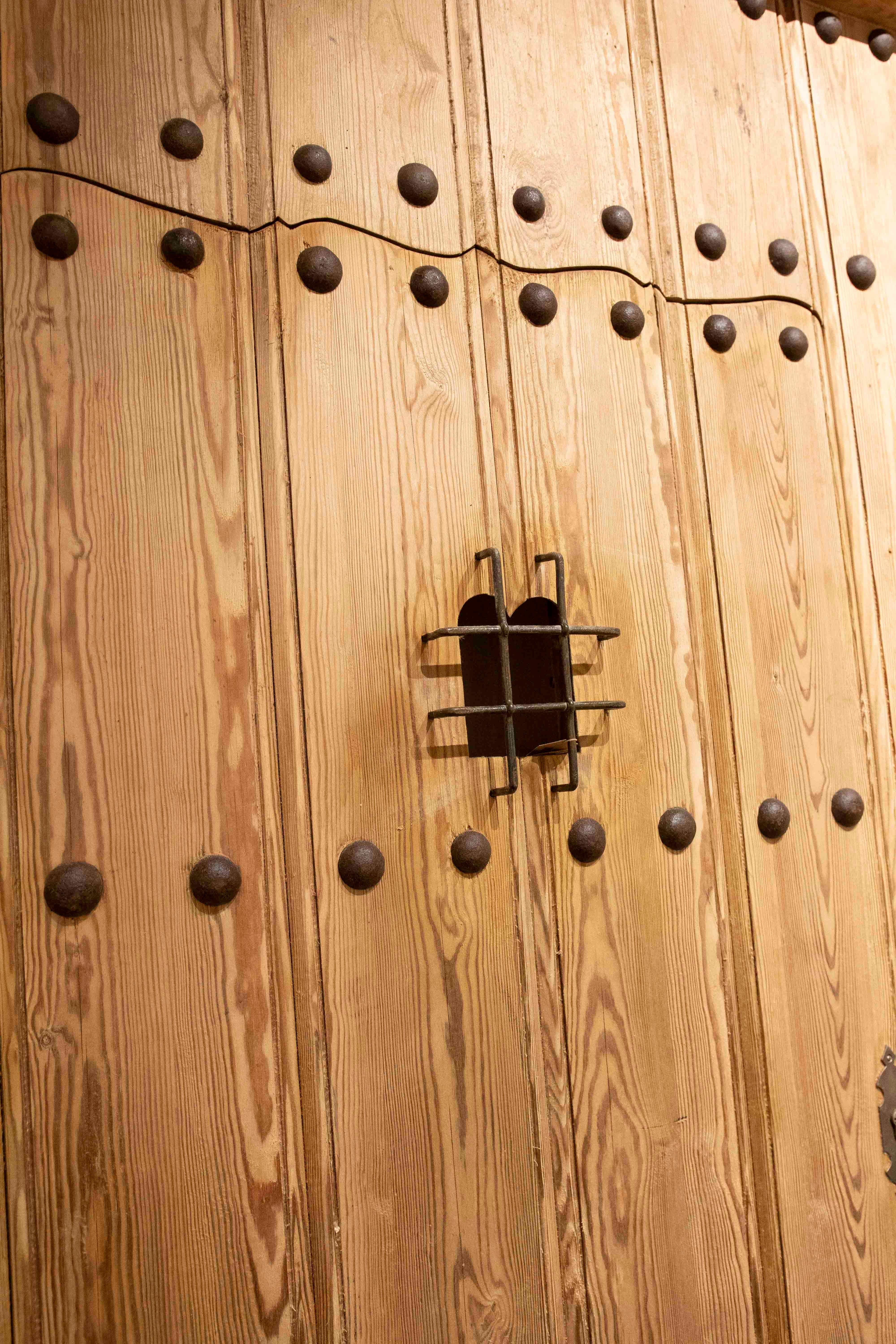 Puerta rústica española de madera de los años 50 con clavos forjados y reja central de hierro Español en venta