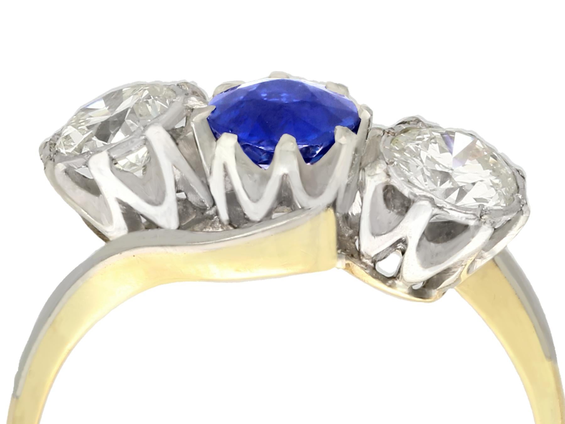 This fine and impressive sapphire and diamond three stone ring has been crafted in 18k yellow gold with a platinum setting.

The twist design mount displays a feature platinum set 0.70Ct round mixed cut natural blue sapphire.

The sapphire is