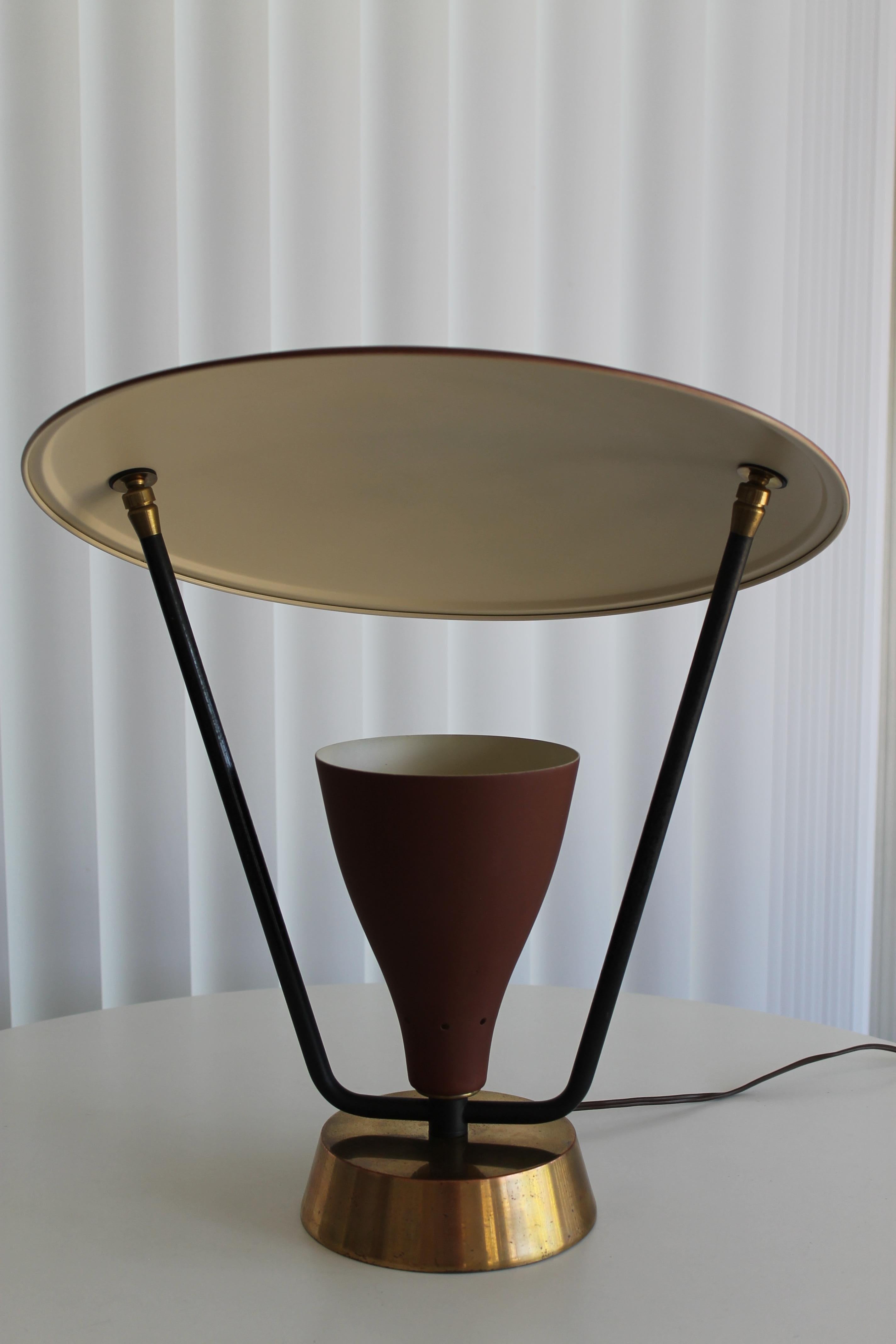 An early 1950s modern lamp with an adjustable saucer light deflector. The light cone is perforated at the base and measures approximately 8