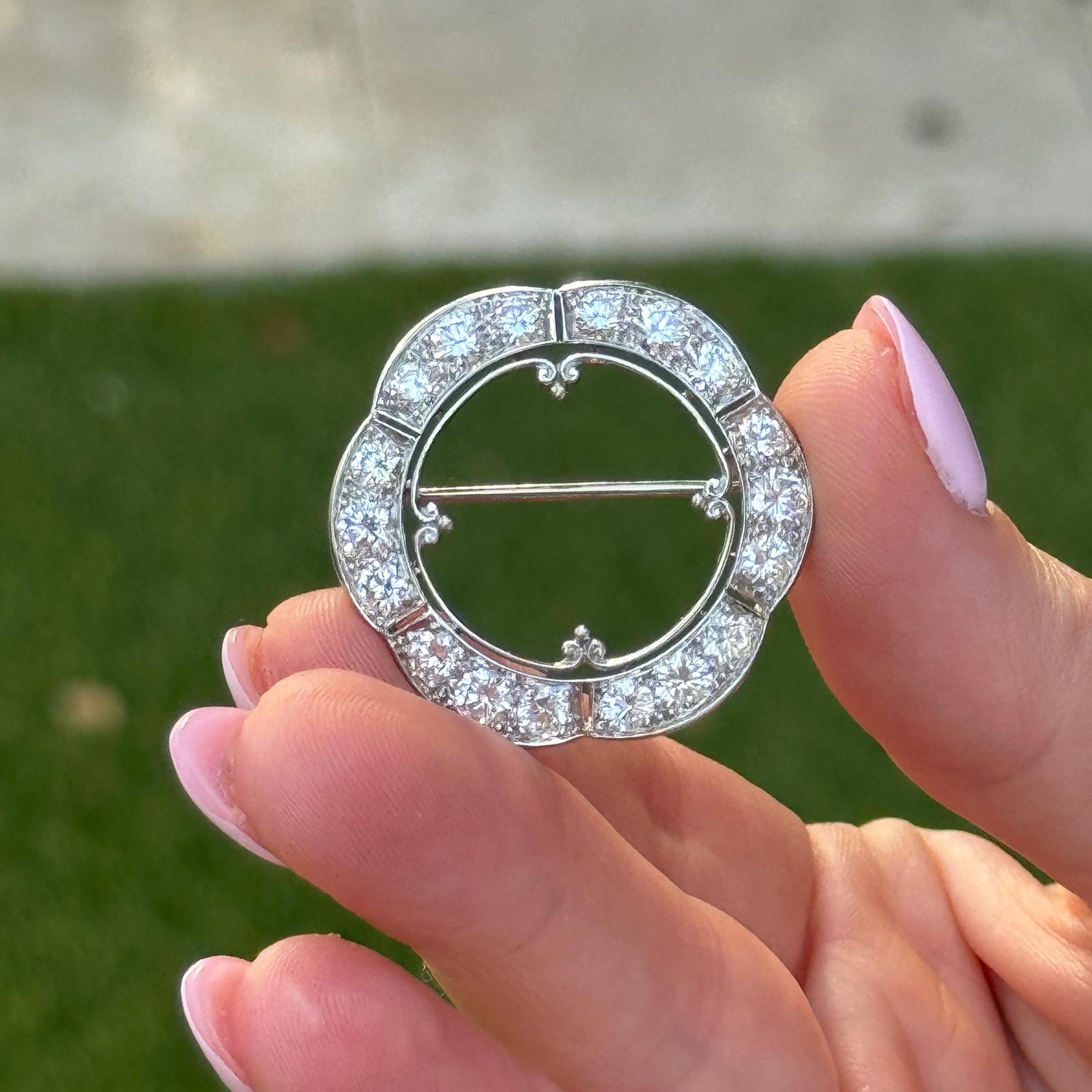 Cette épingle à cercle ouvert des années 1950 est magnifiquement réalisée en platine et présente un design festonné classique orné de 18 diamants ronds de taille brillant d'une valeur totale d'environ 3,50 carats. Les diamants, de couleur G-H et de