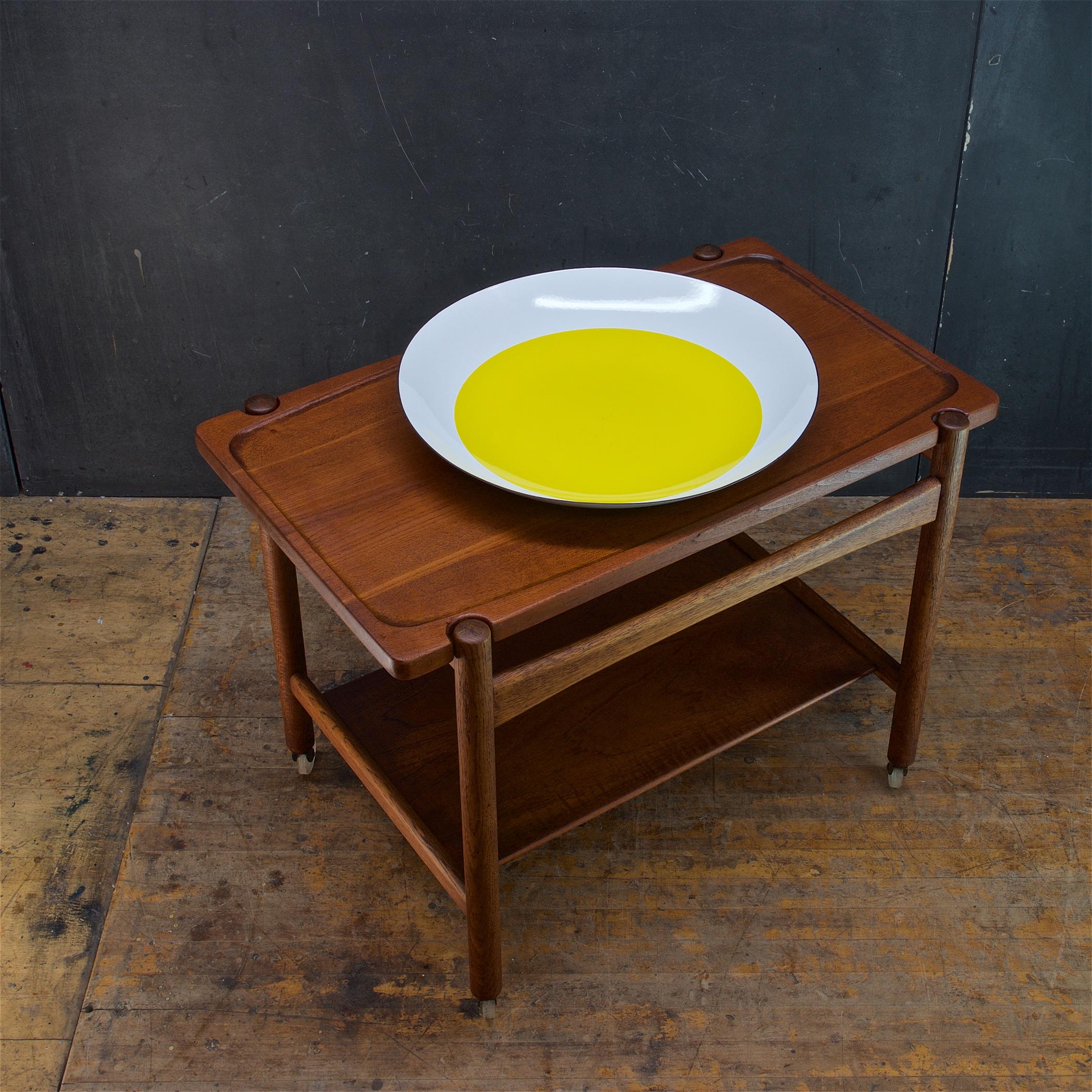 Large pressed steel serving bowl enameled with white and a bright yellow center. Similar to the designs of Arne Clausen for Cathrineholm. This bowl appears to be unused and retains original label.