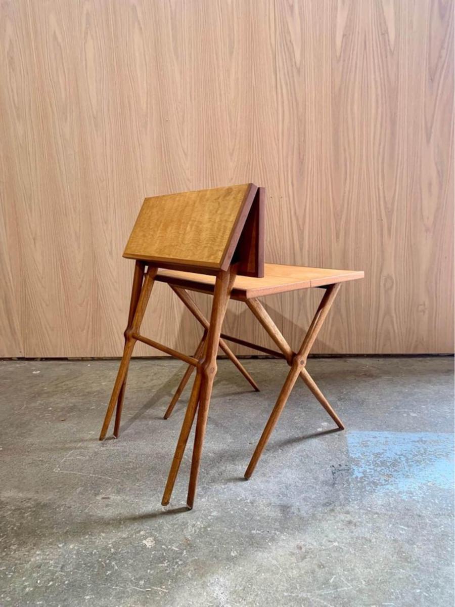 Este exquisito par de mesas auxiliares, probablemente fabricadas en Finlandia o Dinamarca en la década de 1950, presenta unas patas elegantemente esculpidas que se pliegan a la perfección con una tapa abatible, lo que permite guardarlas cómodamente