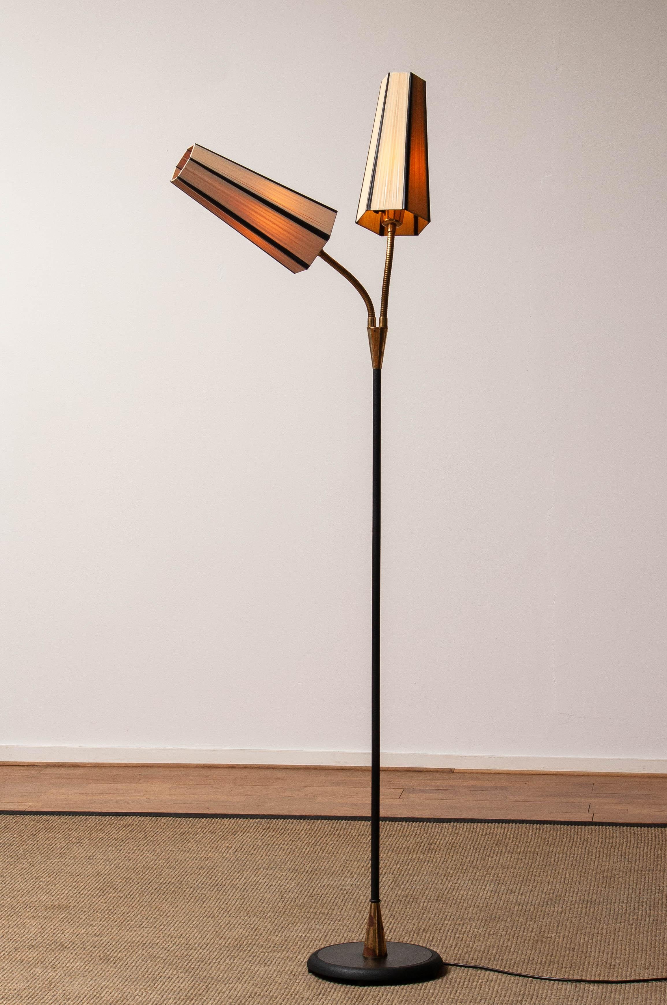 Beautiful and rare iron floor lamp made in Sweden in the 1950's with two shades in polyester fabric both separately switched. Both arms are flexible.
Allover in very good condition and technically 100%. Two twist-switches and both have a screws
