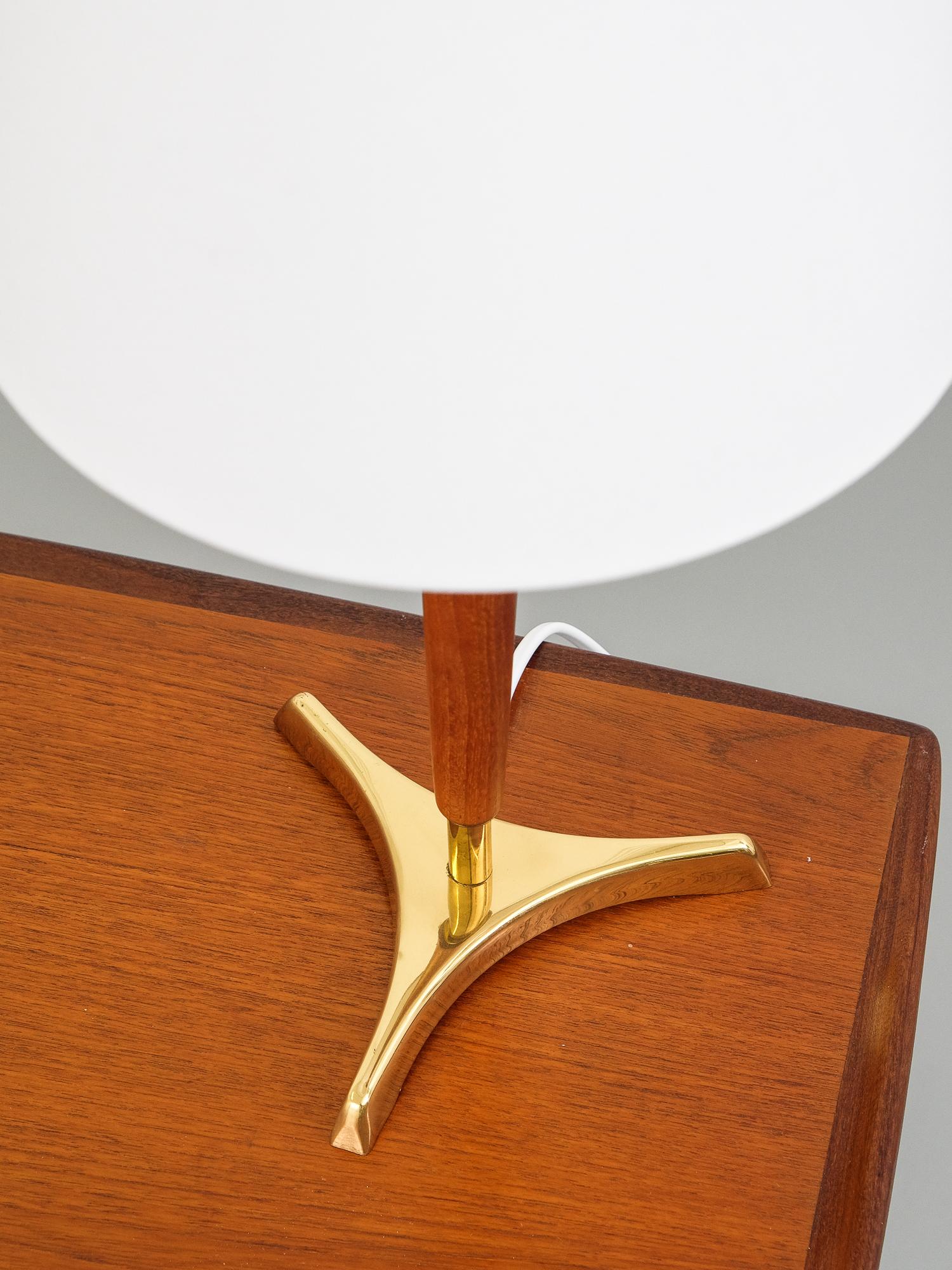 1950s Scandinavian brass and teak table lamp. Unknown manufacturer.

Good condition. Ungrounded wiring. E27 bulb socket.

Height with shade 48 cm.