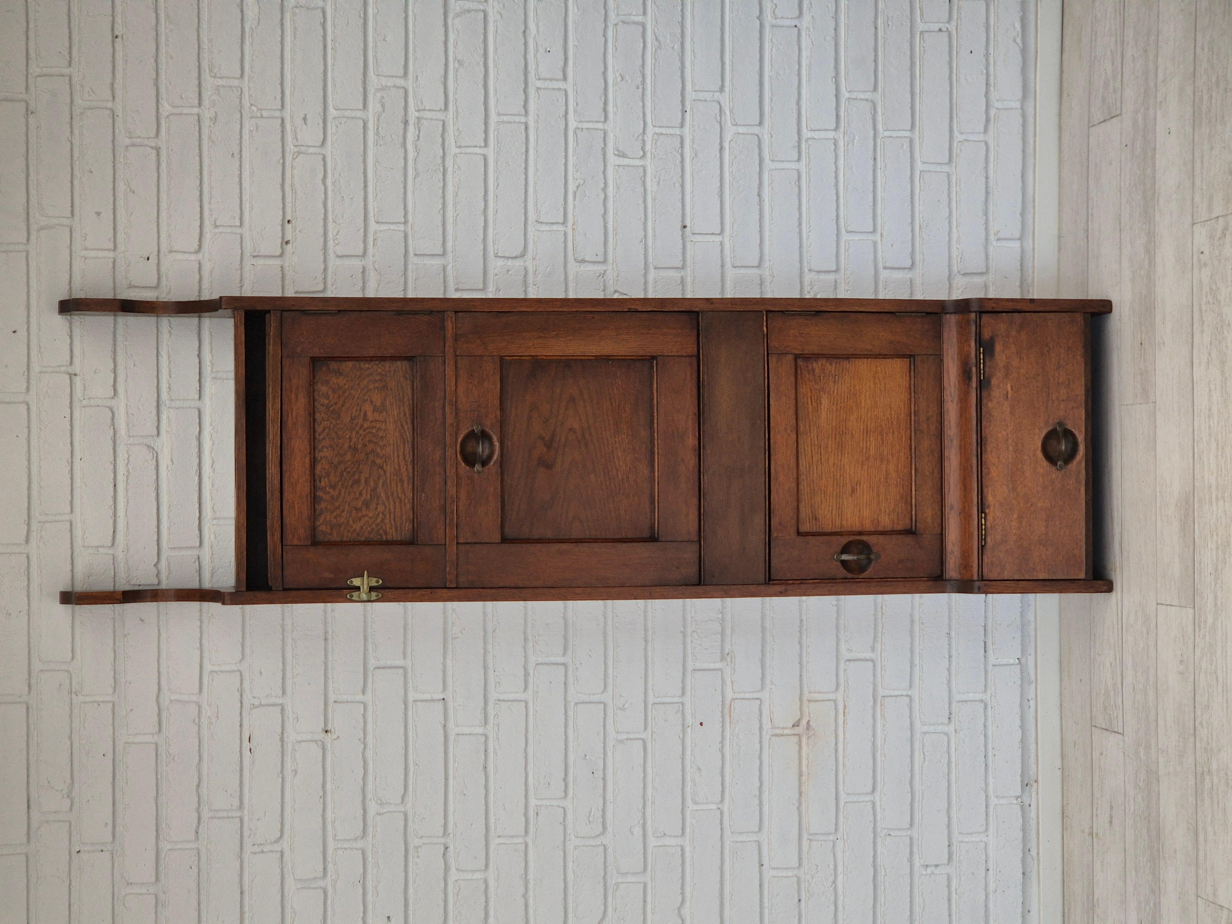 1950s, Scandinavian design. Wall cabinet in original good condition. Oak wood. Places for pots or bottles. Brass handlebar. Space for shoes at the bottom. Manufactured by Scandinavian furniture maker in about 1950s. Original good condition.