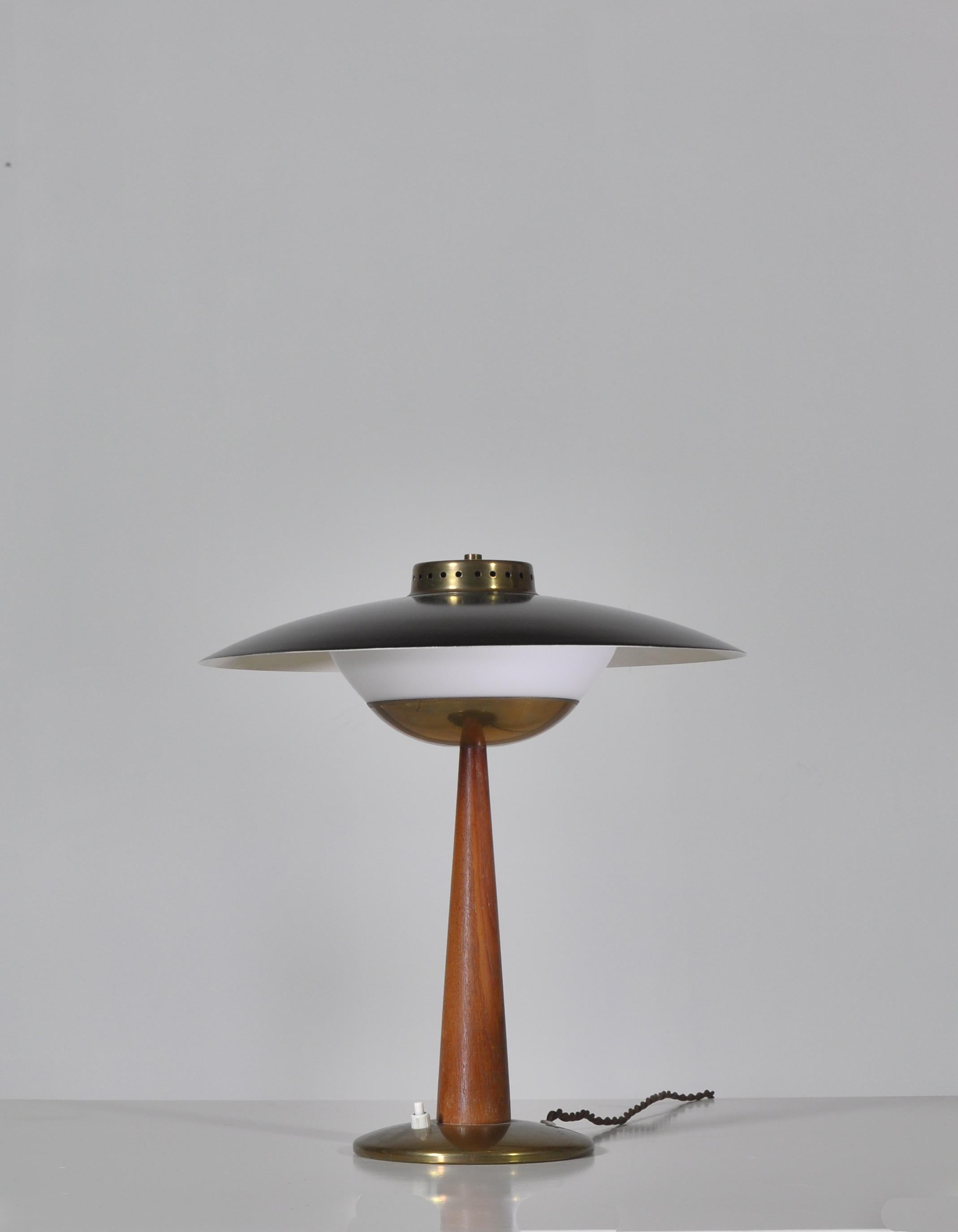 Amazing vintage table lamp made in Scandinavia in the 1950s in the style of Hans Bergström, Svend Aage Holm Sørensen etc. The lamp is produced in high quality materials such as Bangkok teakwood, opal glass and solid brass. It features beautiful and