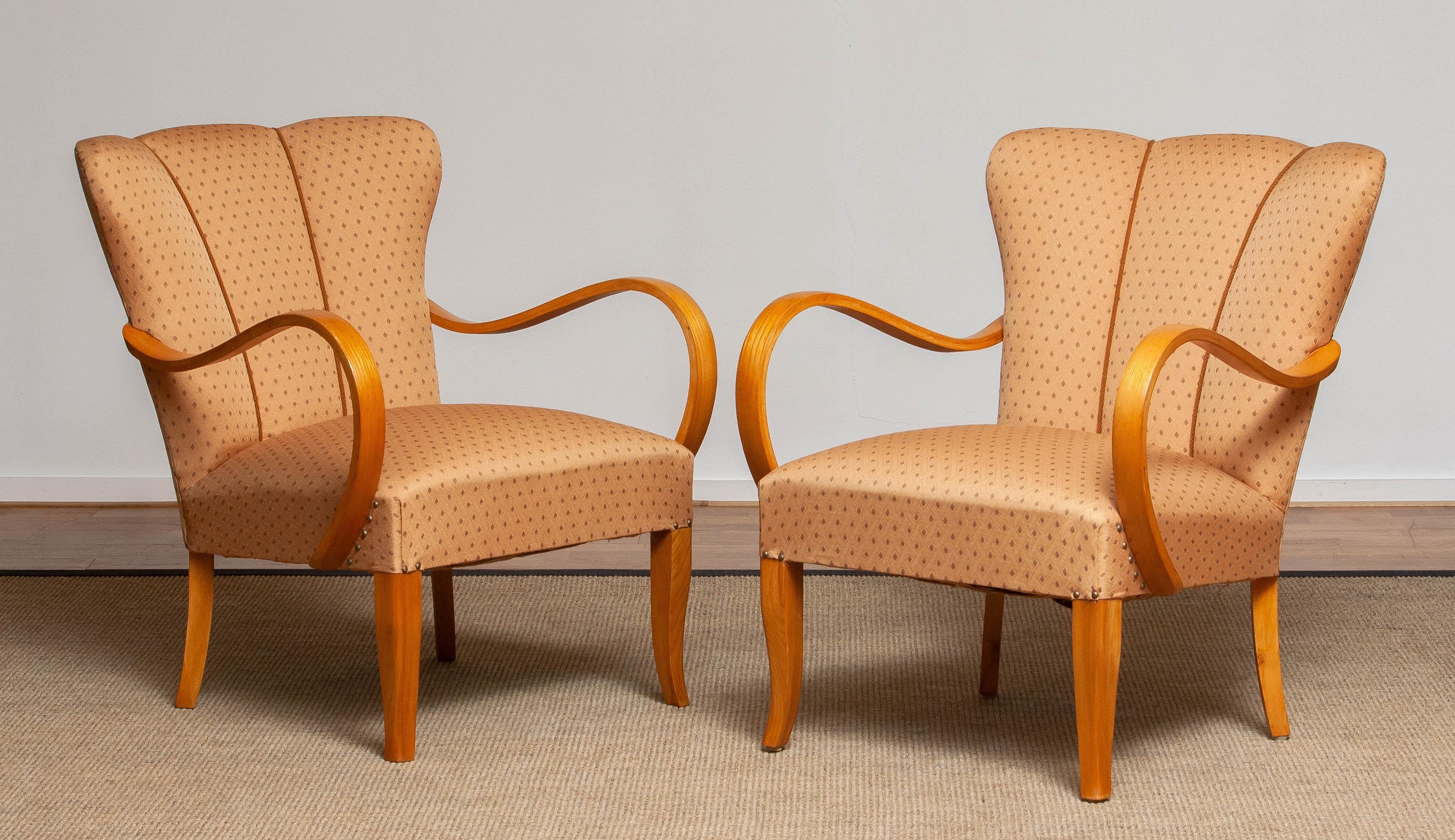 Set of two beautiful 1950's armchairs / easy club chairs with elegant curved bentwood armrests in elm in allover good and clean condition.

Please note!
Because Shipping Costs highly fluctuate daily, we kindly ask you to ask us a Shipping Quote so