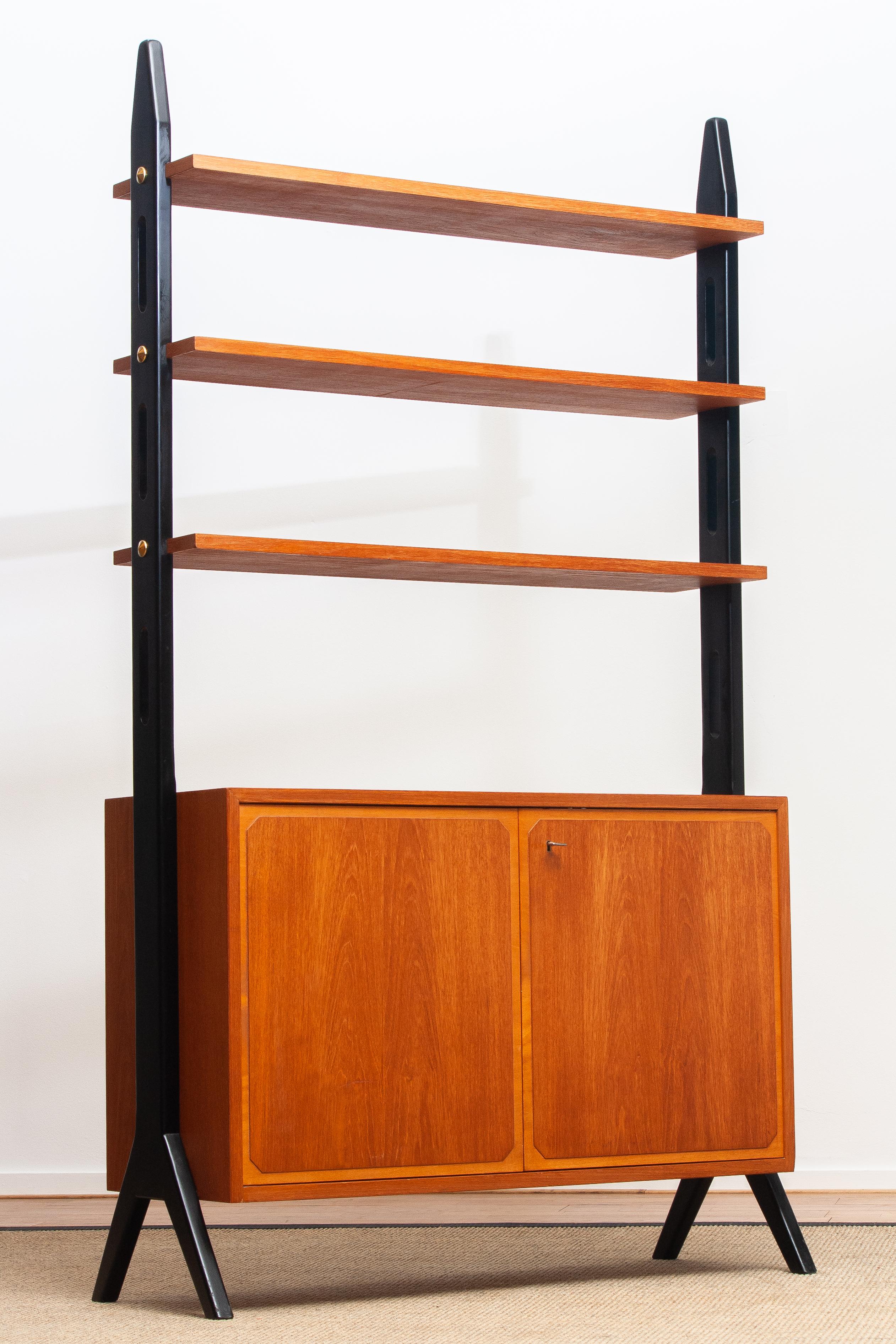 Beautiful Swedish bookcase / room divider / shelfs made in teak from the 1950s.
Two folding doors, with a lock, inside the cabinet is a shelf that can be adjusted in two positions.
The three top shelfs are placed in a fixed position.
Overall