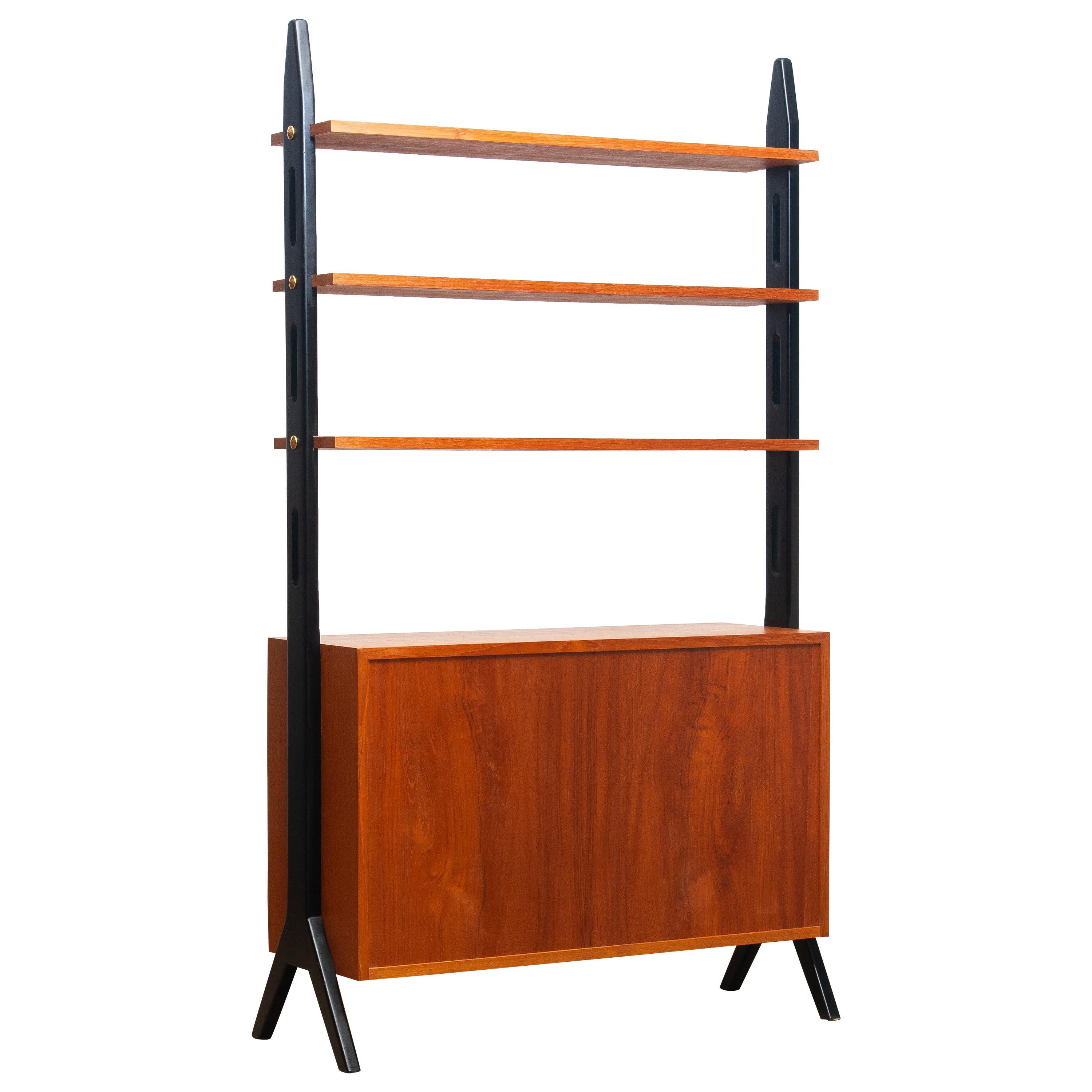 Beautiful Swedish bookcase / room divider / shelf’s made in teak from the 1950s.
Two folding doors, with a lock, inside the cabinet is a shelf that can be adjusted in two positions.
The three top shelf’s are placed in a fixed position.
Overall