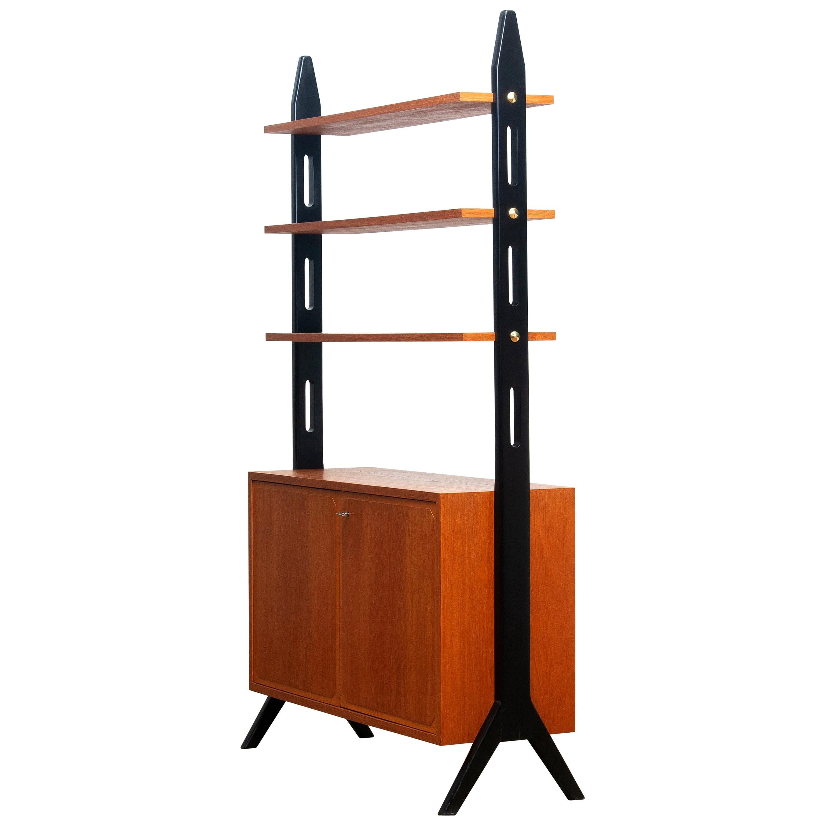 Beautiful Swedish bookcase / room divider / shelf’s made in teak from the 1950s.
Two folding doors, with a lock, inside the cabinet is a shelf that can be adjusted in two positions.
The three top shelf’s are placed in a fixed position.
Overall