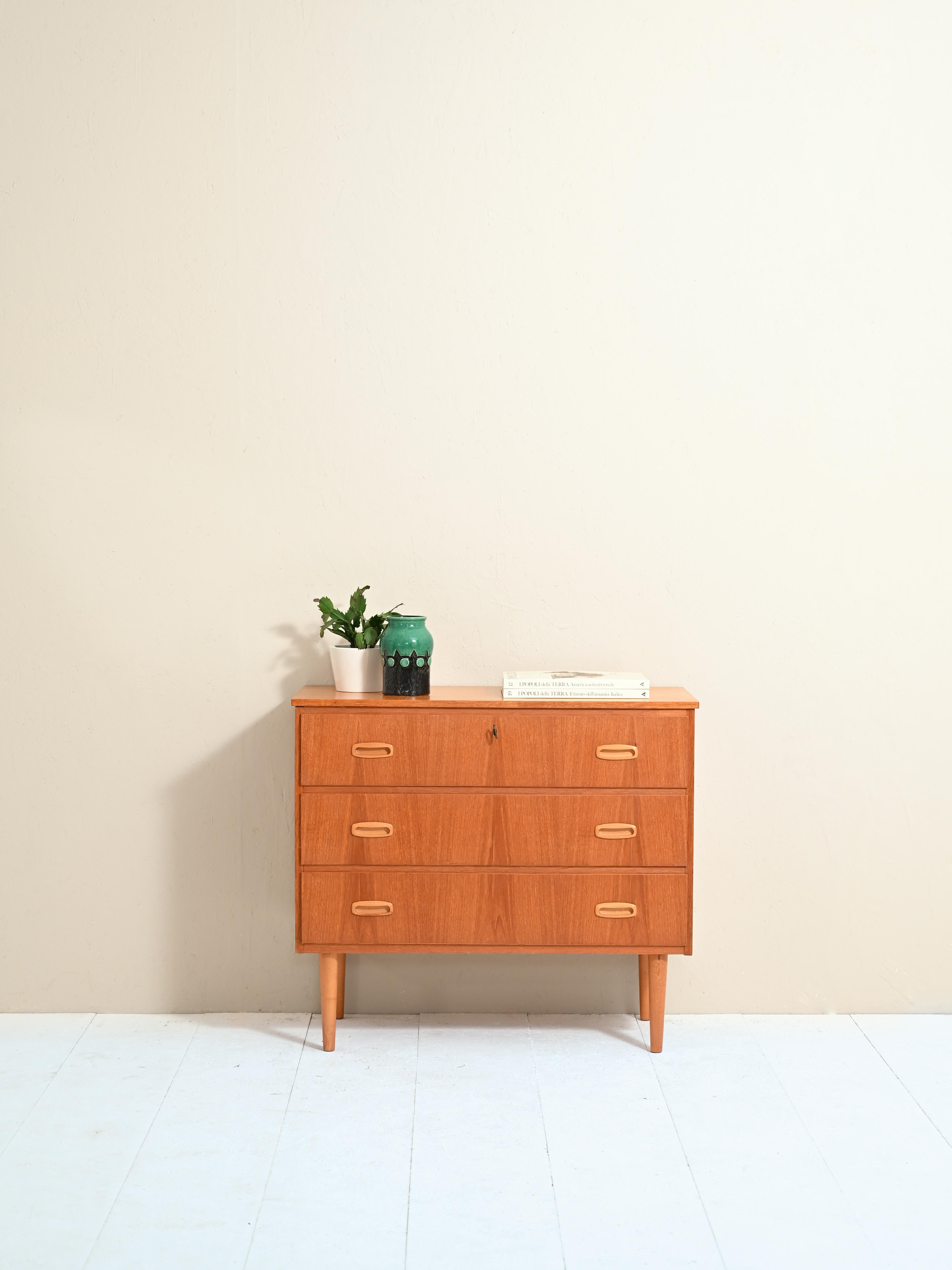 Cabinet with 3 drawers of Scandinavian manufacture.

Features a top with beveled corners and conical legs, typical of Northern Europe.

The drawers have carved wooden handles and the first one has a lock.

The small size also makes it perfect