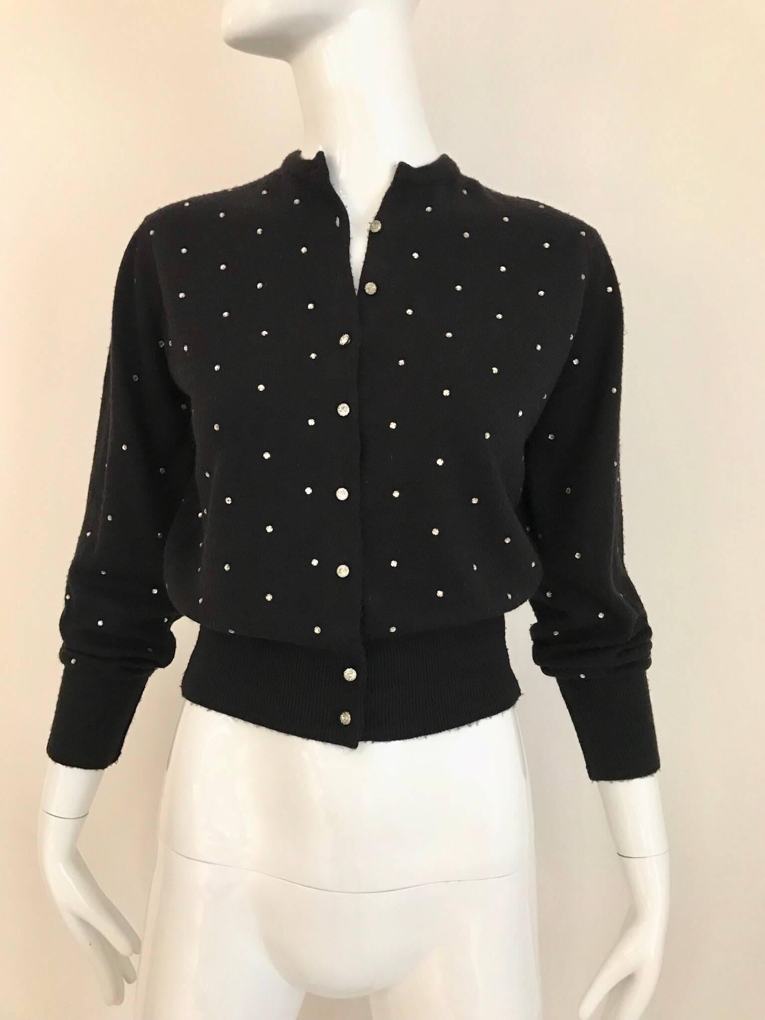 Elegant Vintage black sweater from 1950's by Schiaparelli in cashmere with a sparkle of rhinestones. The waist band further defines the feminine shape!
Size: Small (4 or 6) 
**missing 1 button on the fold 