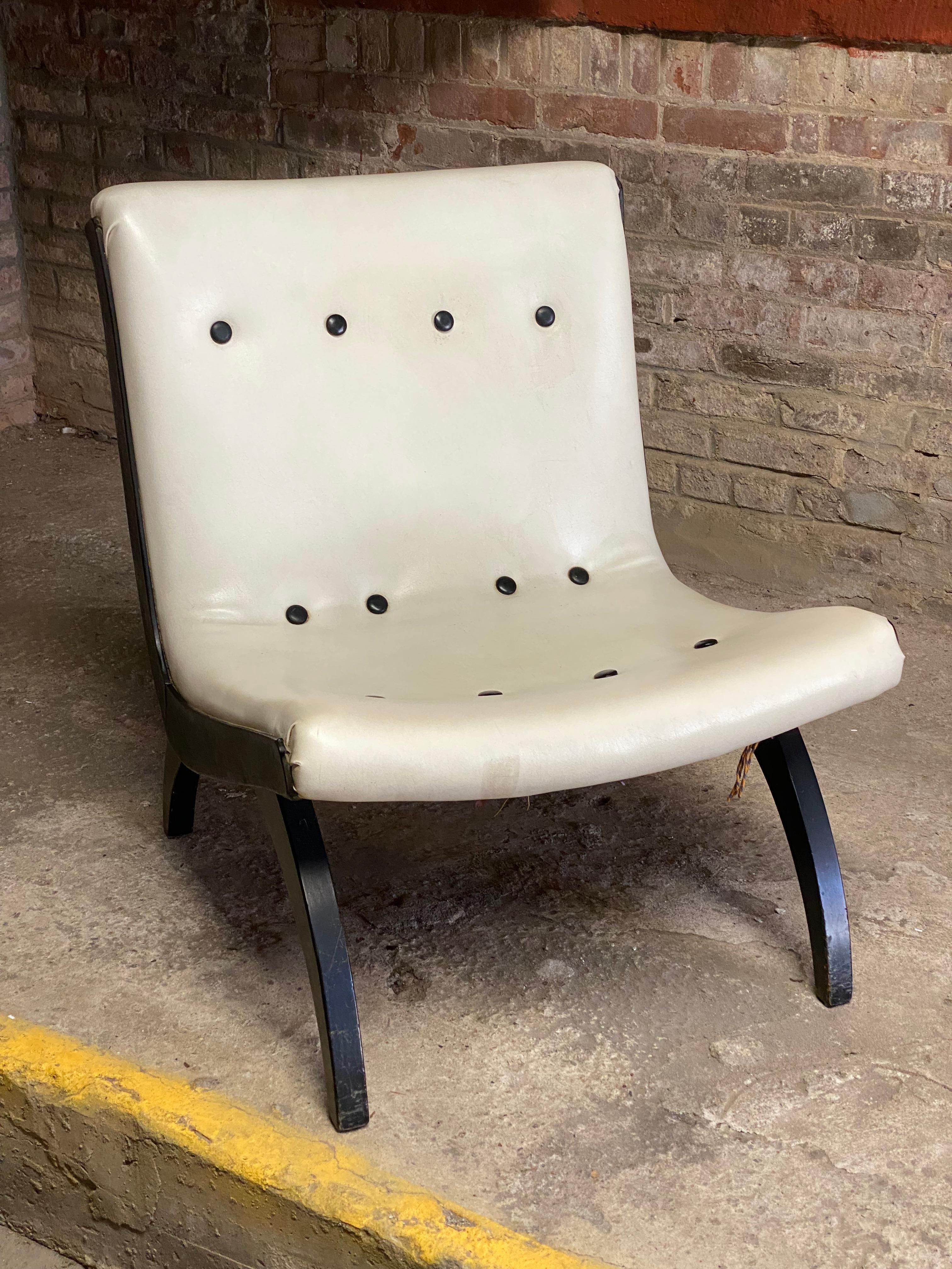 Stylish Mid Century Modern black and white scoop lounge chair. Circa 1950-55. Black wood frame with buttoned back and seat upholstered in white naugahyde. Good overall condition. Structurally sound and sturdy construction. Wear consistent with age