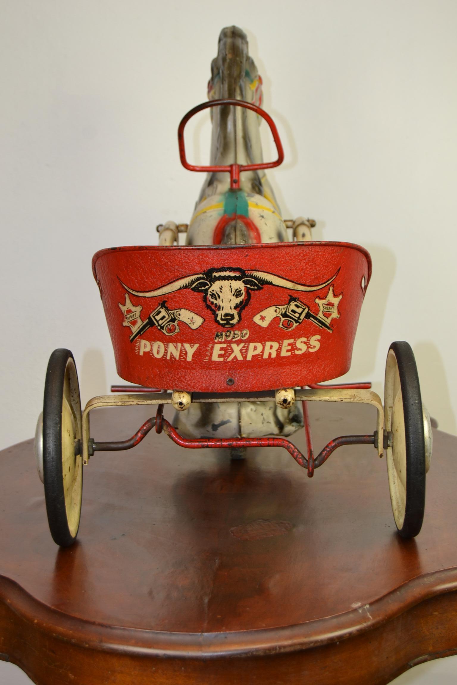 1950s vintage Mobo Toys pony express pedal toy.
This Carrey Trailer with Horse was made by Sebel Mobo Toy, D. Sebel & co Erith Kent, England.
It's a pressed steel toy with pedals of a cute pony with a Carrey trailer cart. 

This child's ride