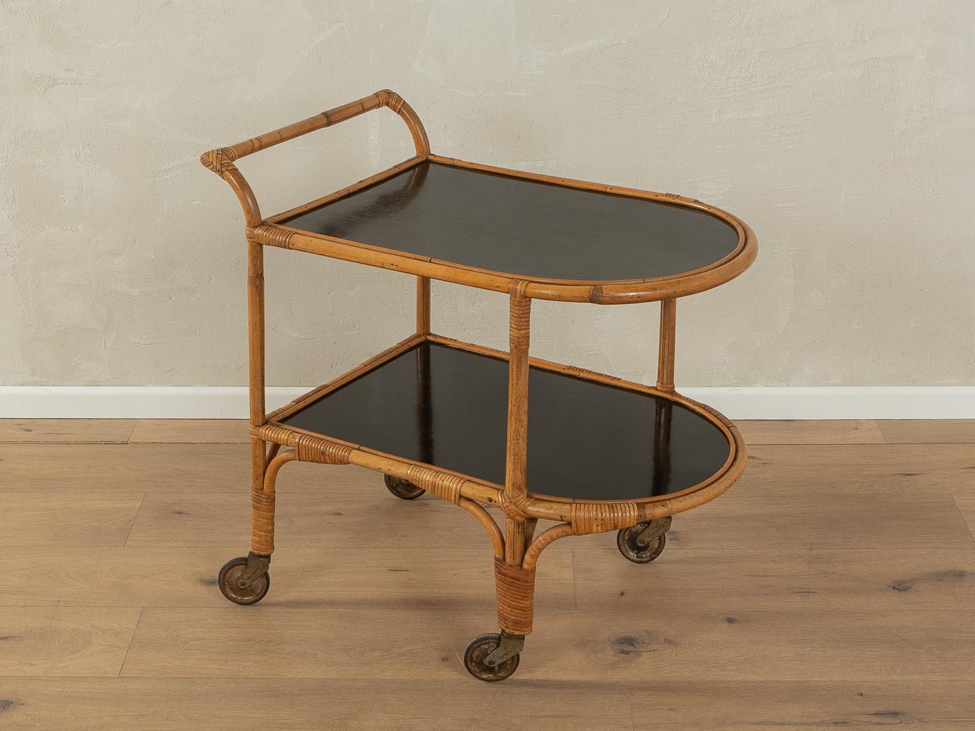 Rare serving trolley from the 1950s. Frame made of bamboo with two shelves featuring original formica coating in black and brass wheels.

Quality Features:

    very good workmanship
    high quality materials
    Made in Germany

Castors with