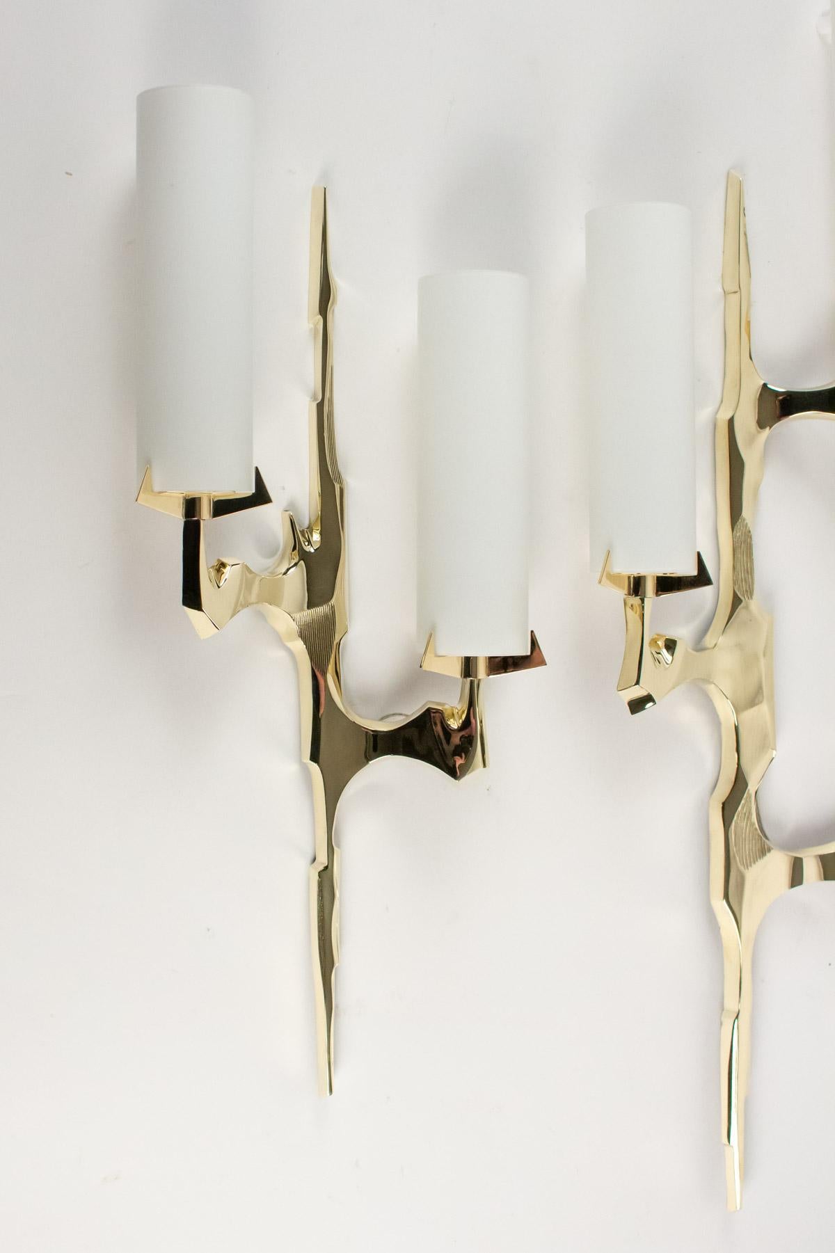 The sconces are made of gilded bronze. The set is composed by 2 sconces of different size.
The highest sconce features three bulbs with cylindrical opalin glass shades.
Measures: H 29.93 in. x W 11.03 in. x D 3.15 in.
The other features 2 bulbs