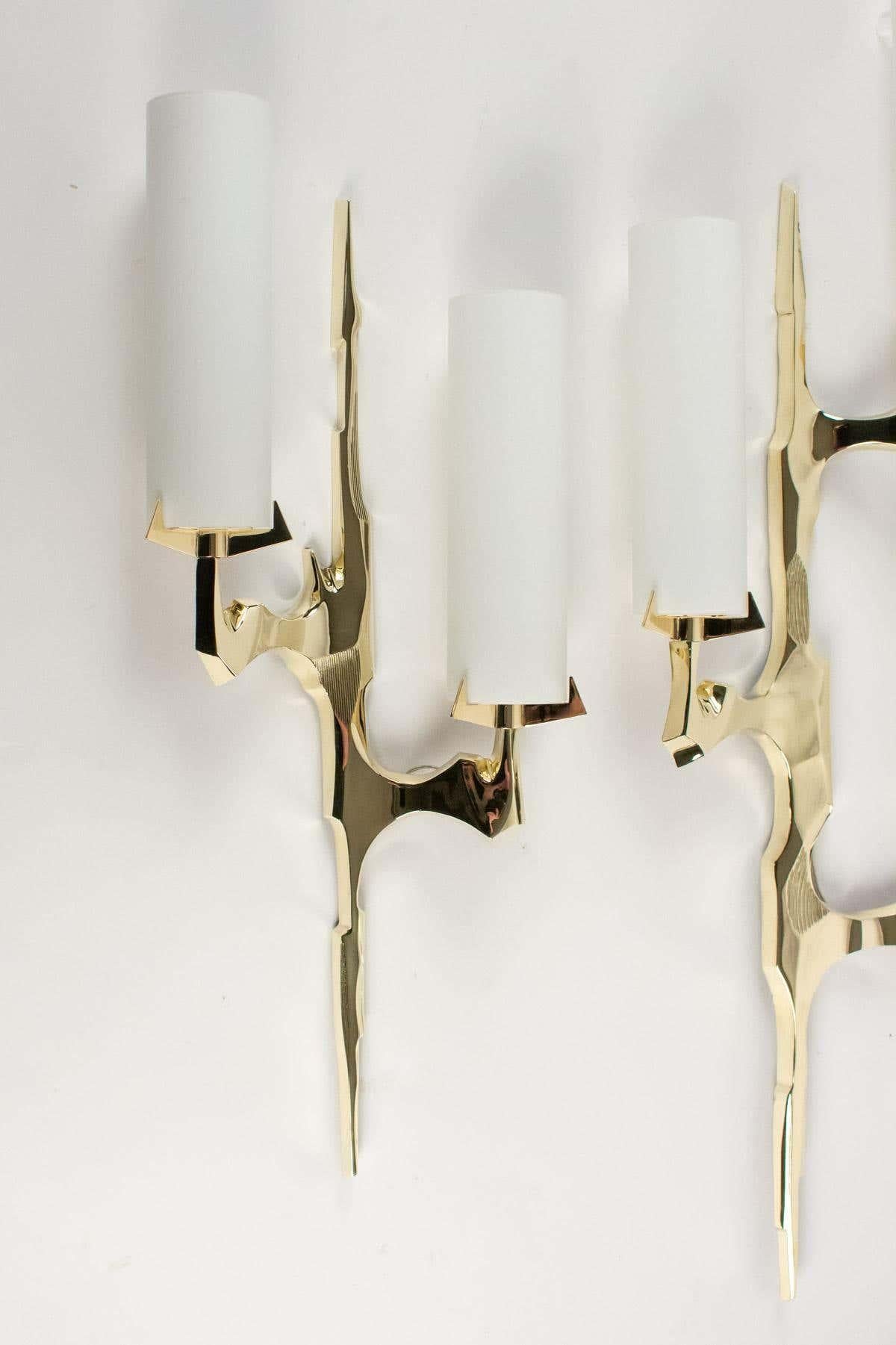 The wall lights are in gilded bronze inspired by tree branches.
The set consists of 2 wall lights of different sizes.
The tallest wall lamp has three bulbs with cylindrical opaline glass shades. Measures: H 29.93