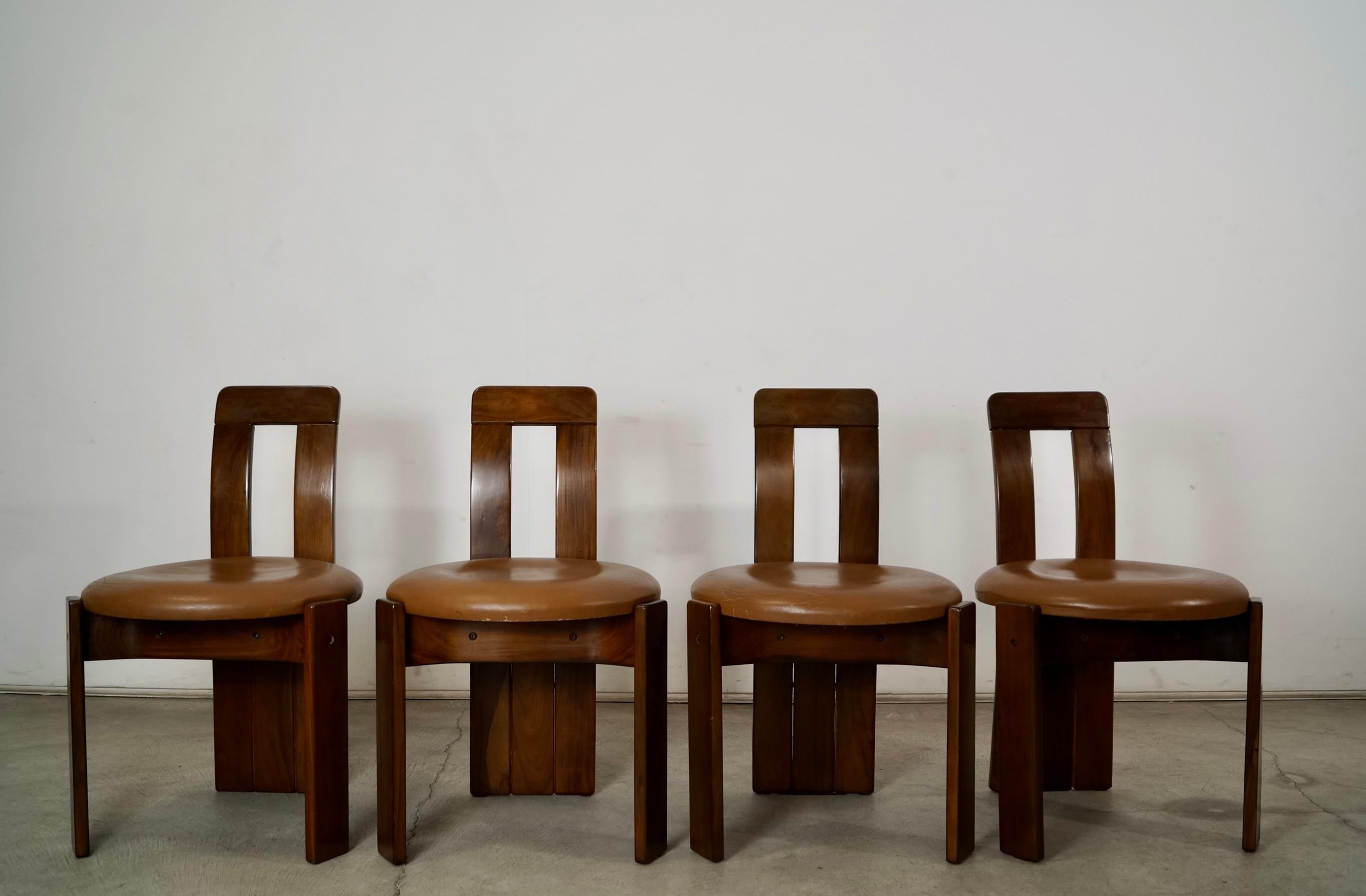 Set of four original vintage Mid Century Modern dining chairs for sale. Designed by famed designed Sergio Rodrigues, and were manufactured in 1957. These are made of solid hardwood jacaranda or Brazilian Rosewood, and are incredibly solid and well