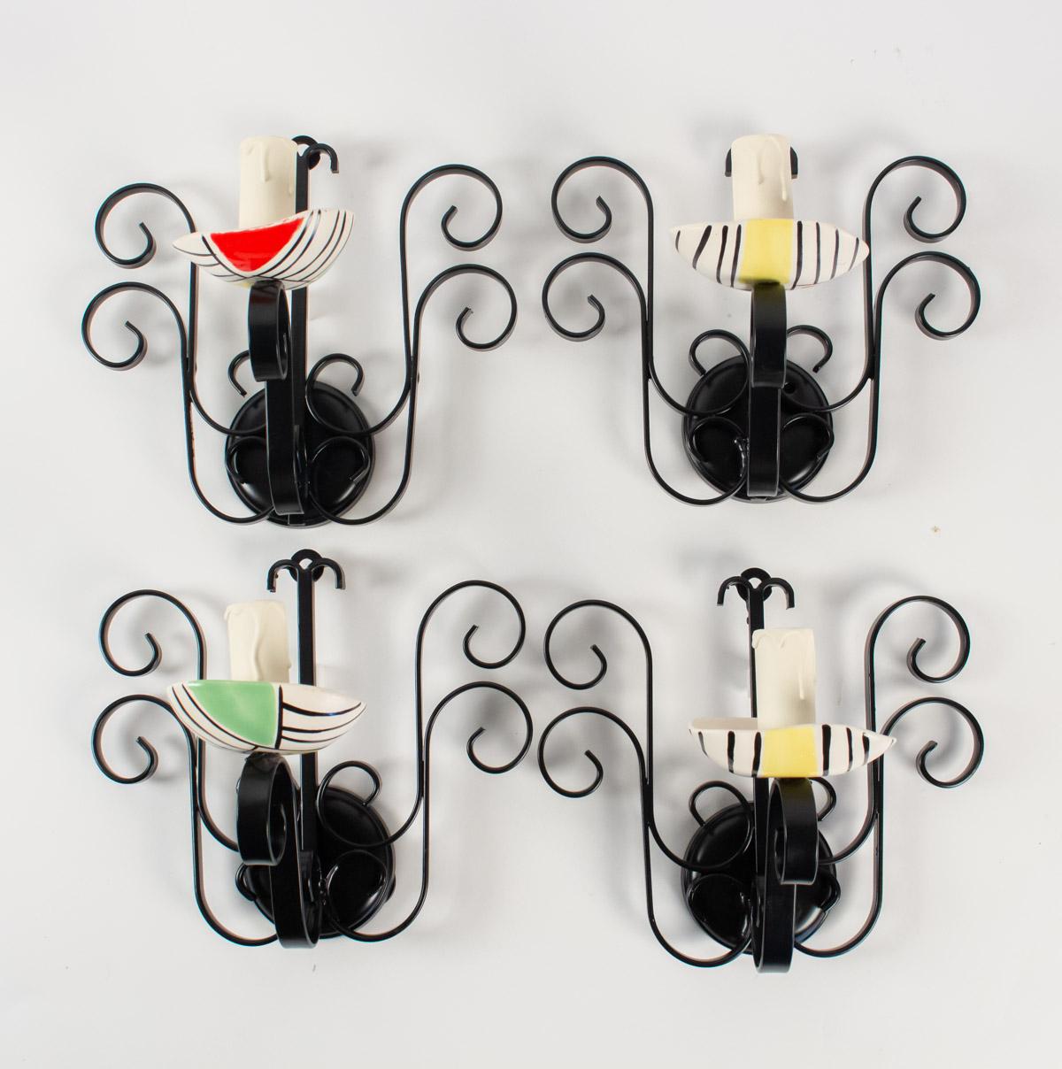The back plates are made of black lacquered wrought iron. Each sconces are highlighted with ceramics cups. These white ceramics cups are hand painted with yellow, red, green and black touches.
Stylish art work typical of 1950s Vallauris