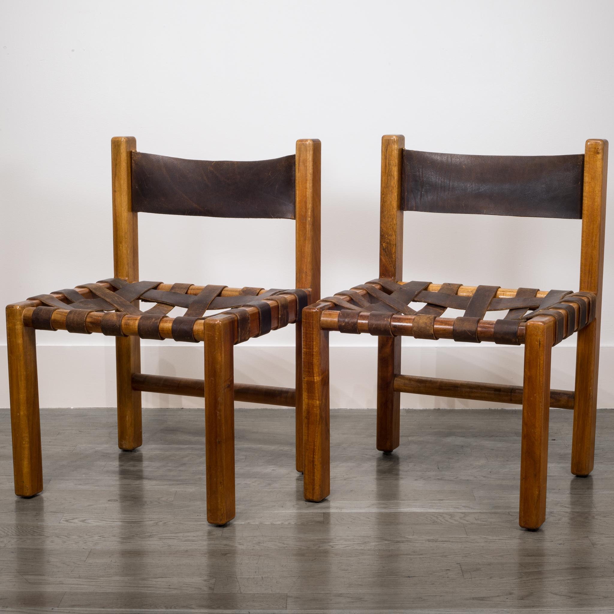 A set of two studio crafted chairs, made of a sturdy koawood frame with rounded corners. The backrest and seating are made of a red-brown leather with a beautiful and heavy patina. The back is made of one piece of leather and the seating is webbed.