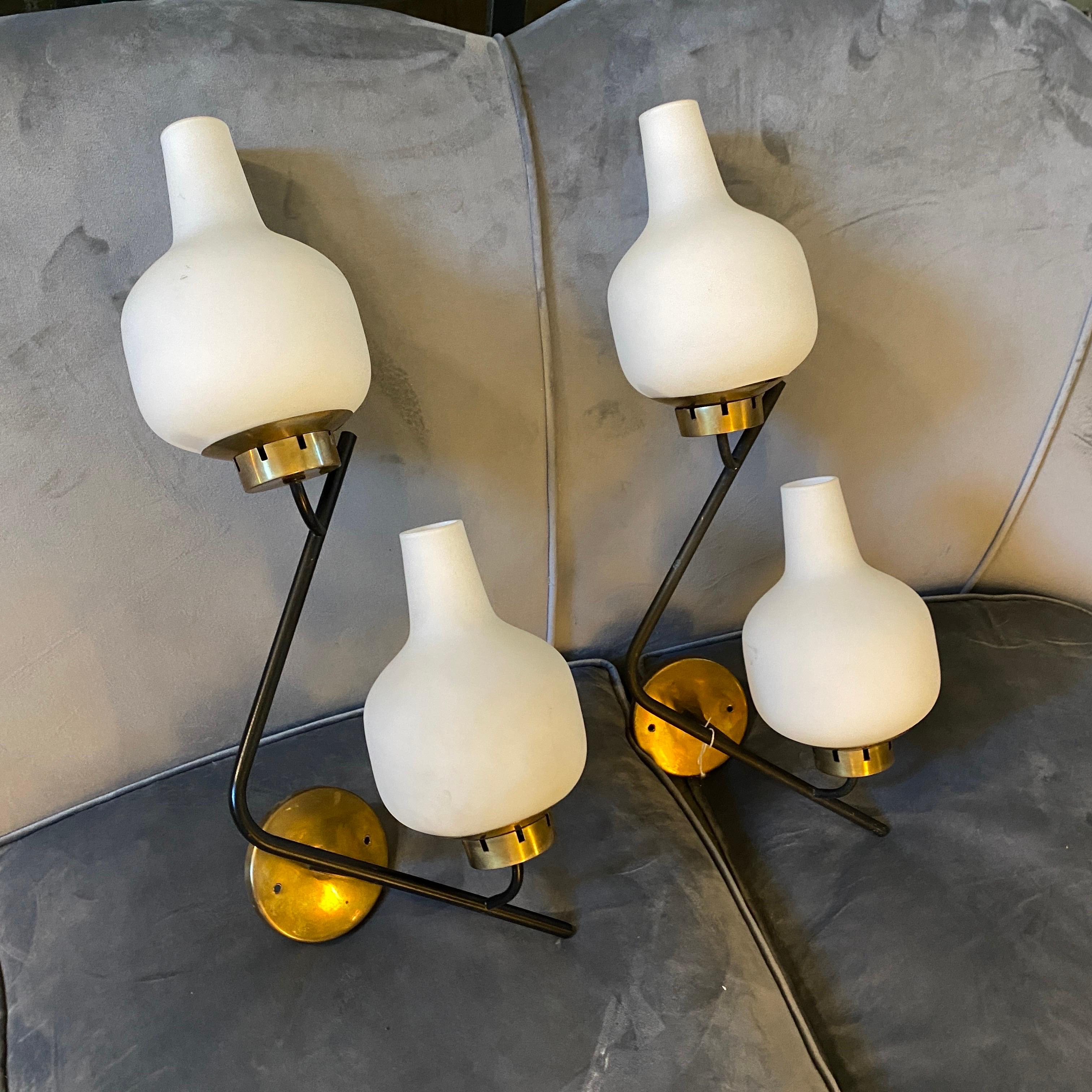 A pair of high quality zig zag wall sconces designed and manufactured in Italy in the 1950s by Stilnovo, brass it's in original patina, original white glass diffusors are in good conditions, they work both 110-240 volts and need regular e14 bulbs.