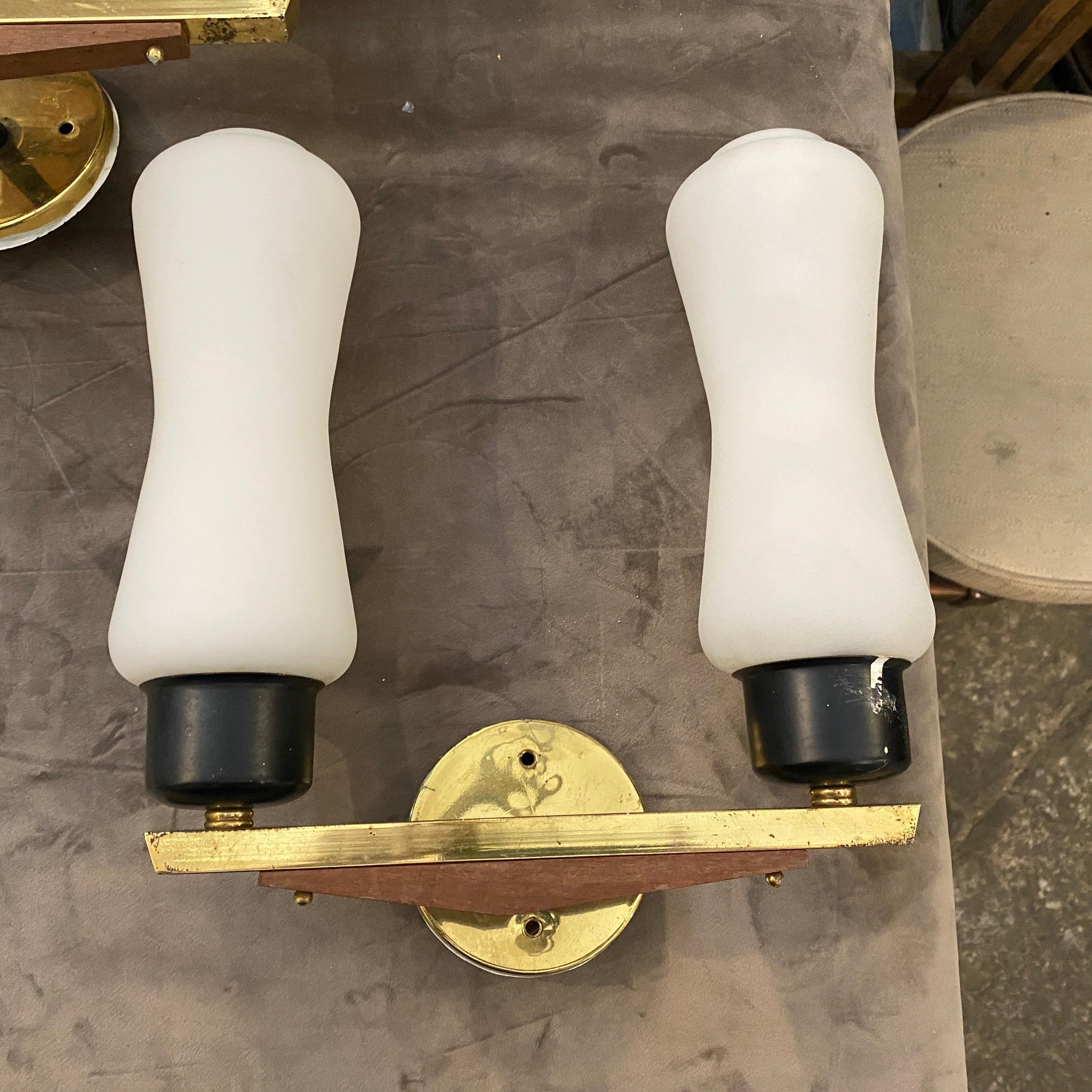 A pair of brass, teak and opaline glass wall sconces designed and manufactured in Italy in the Fifties in the manner of Stilnovo. They work both 110-240 volt and need regular e14 bulbs. Original conditions gives them a lovely vintage look.
These