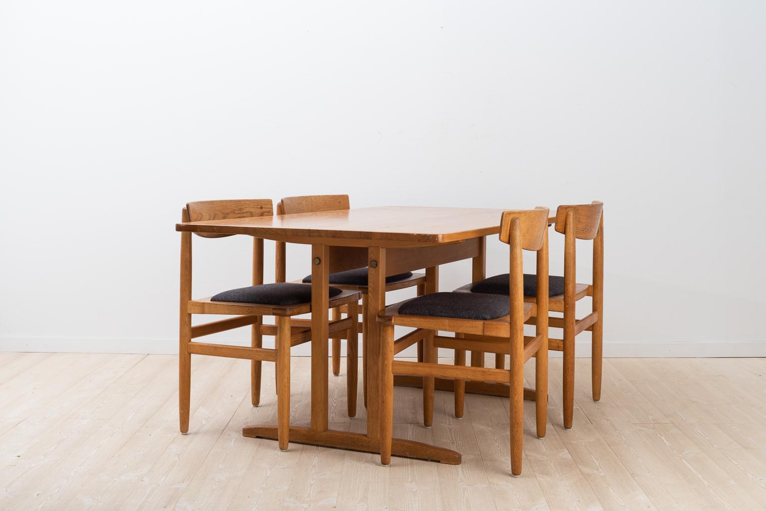 Swedish dining group with a table and four chairs. Designed by Börje Mogensen during the 1950s. Manufactured from oak and produced by Karl Andersson & Söner. The dining group is in the so called Shaker style. The pieces are marked with an